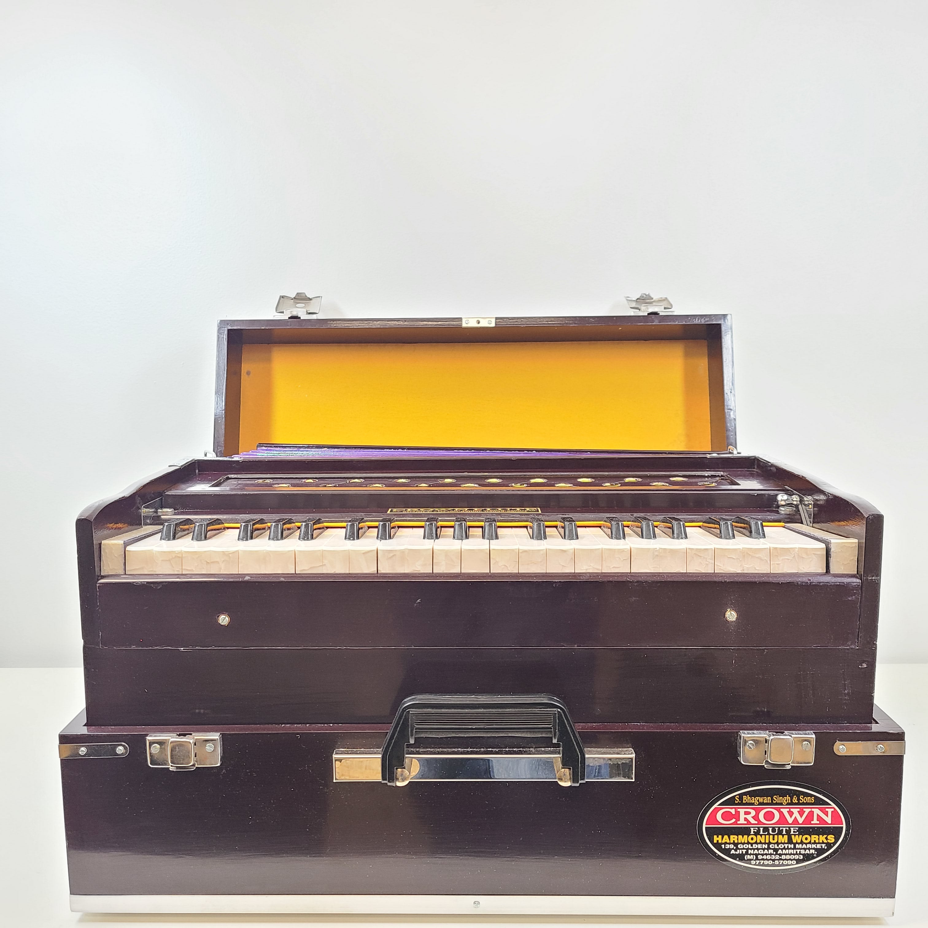 Classic S. Bhagwan Singh & Sons Crown Flute harmonium in black, blue, and brown with a carrying case included.