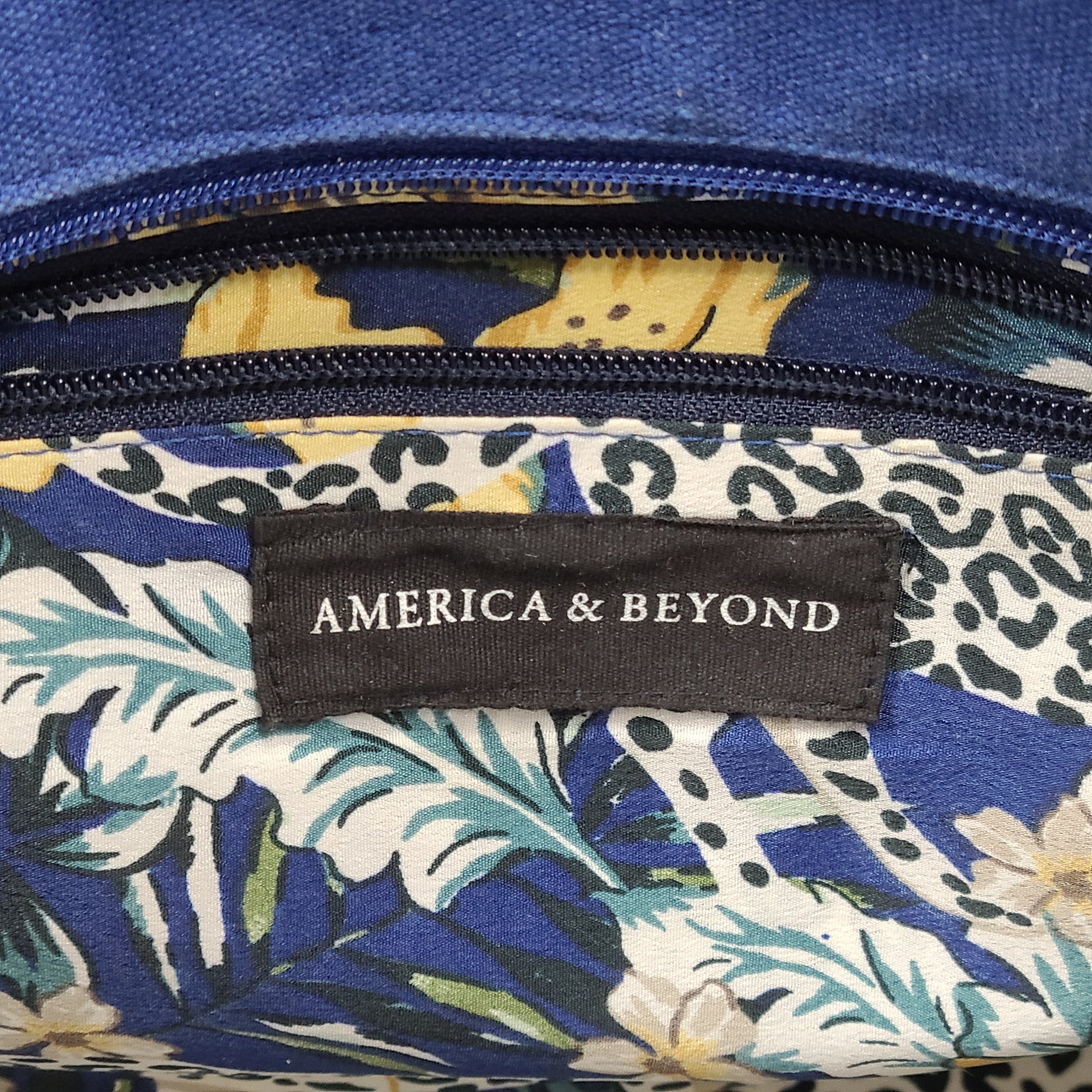 America & Beyond embroidered blue and white tote with floral and leopard interior and interior label reading AMERICA & BEYOND.
