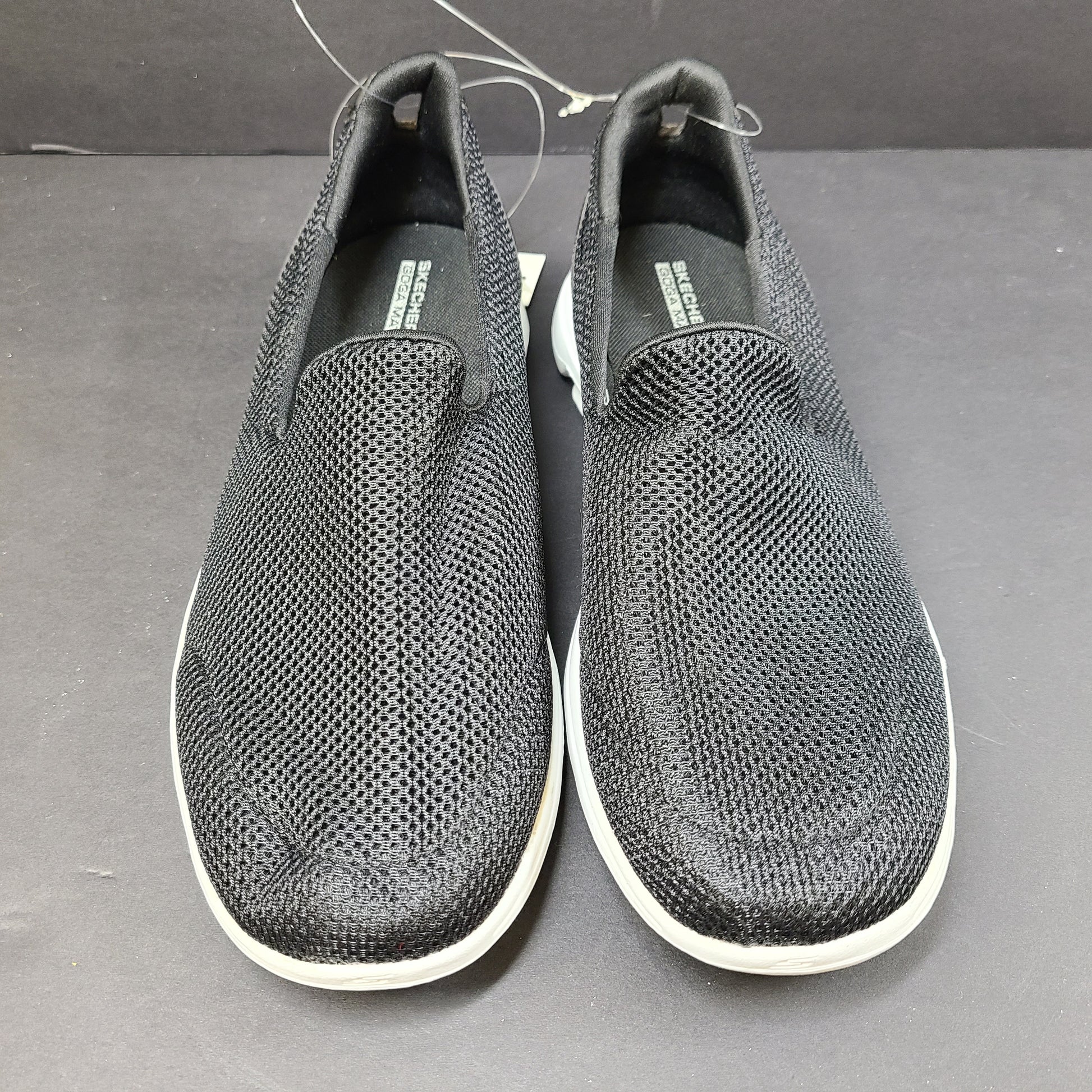 Black and white Skechers Go Walk 5 slip-on shoes with responsive cushioning and Quick-Fit heel for easy on and off.