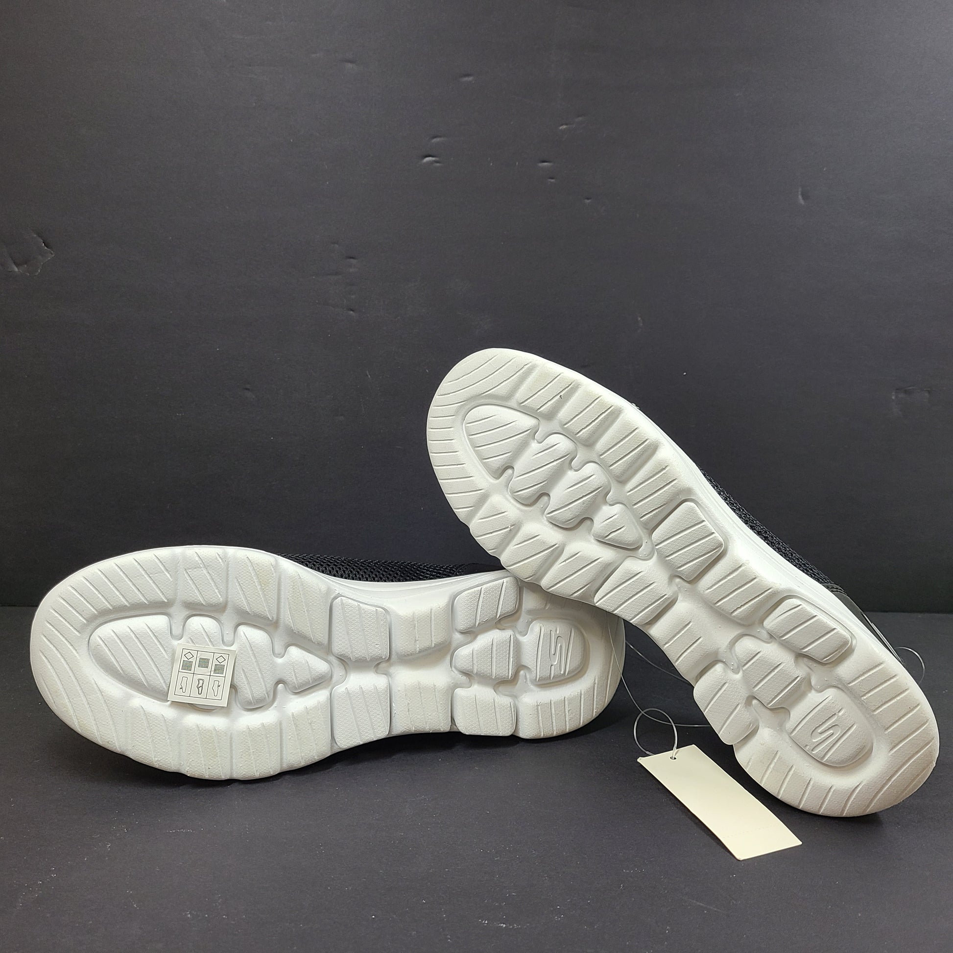 Black and white Skechers Go Walk 5 slip-on shoes with responsive cushioning and Quick-Fit heel for easy on and off.