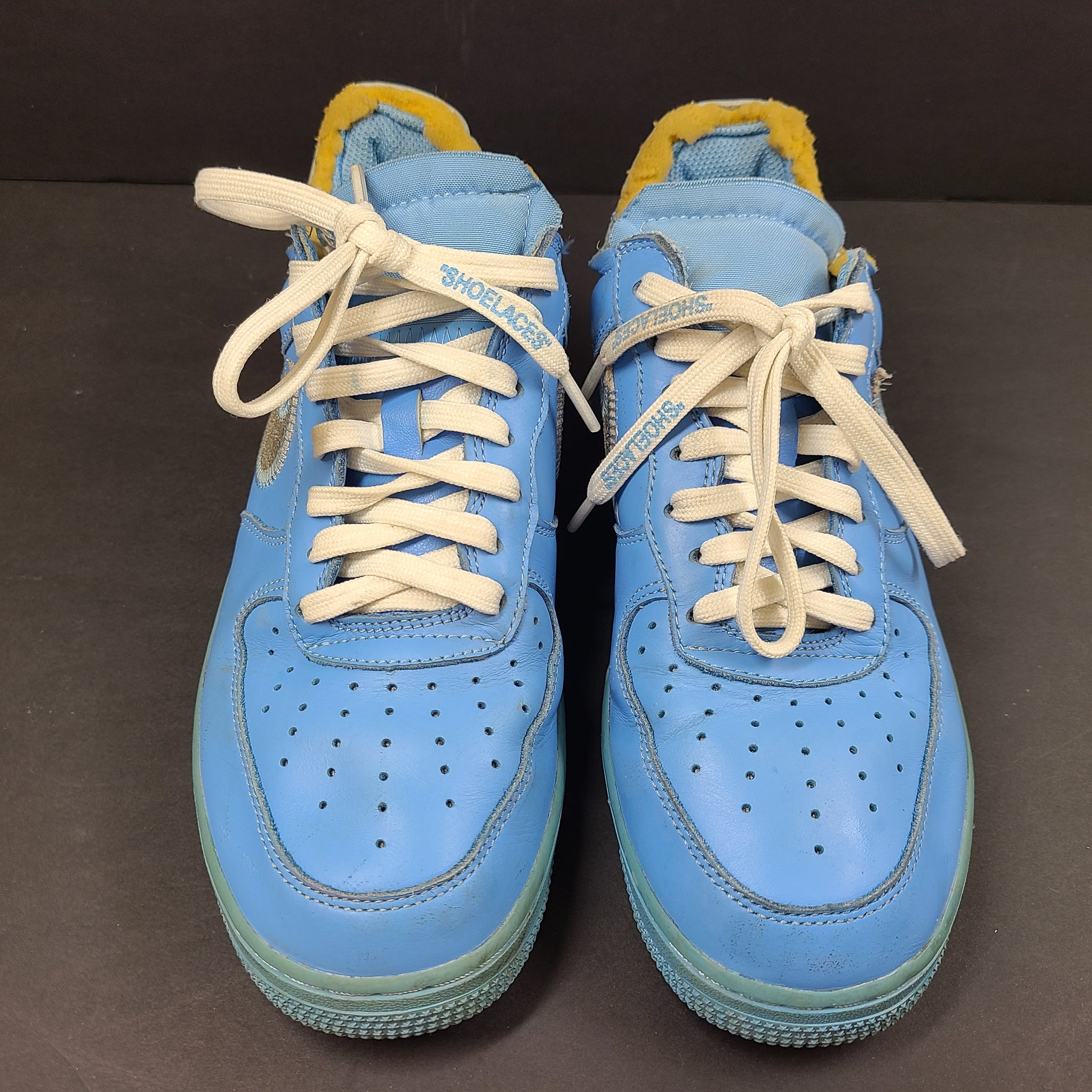 Nike Air Force 1 low-top sneakers in blue and yellow, size US 7, featuring "SHOELACES" text on the laces and "AIR" on the sole.