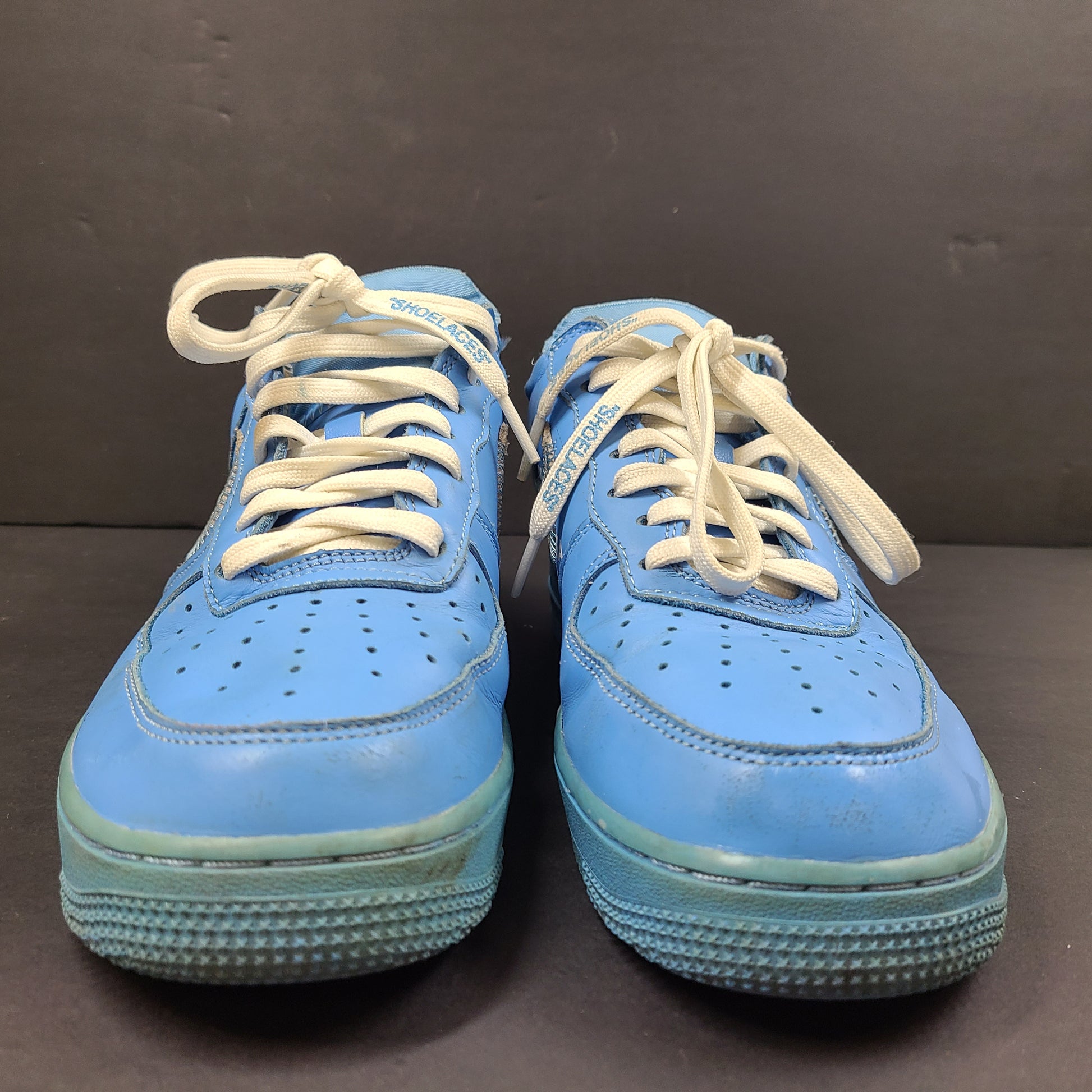 Nike Air Force 1 low-top sneakers in blue and yellow, size US 7, featuring "SHOELACES" text on the laces and "AIR" on the sole.