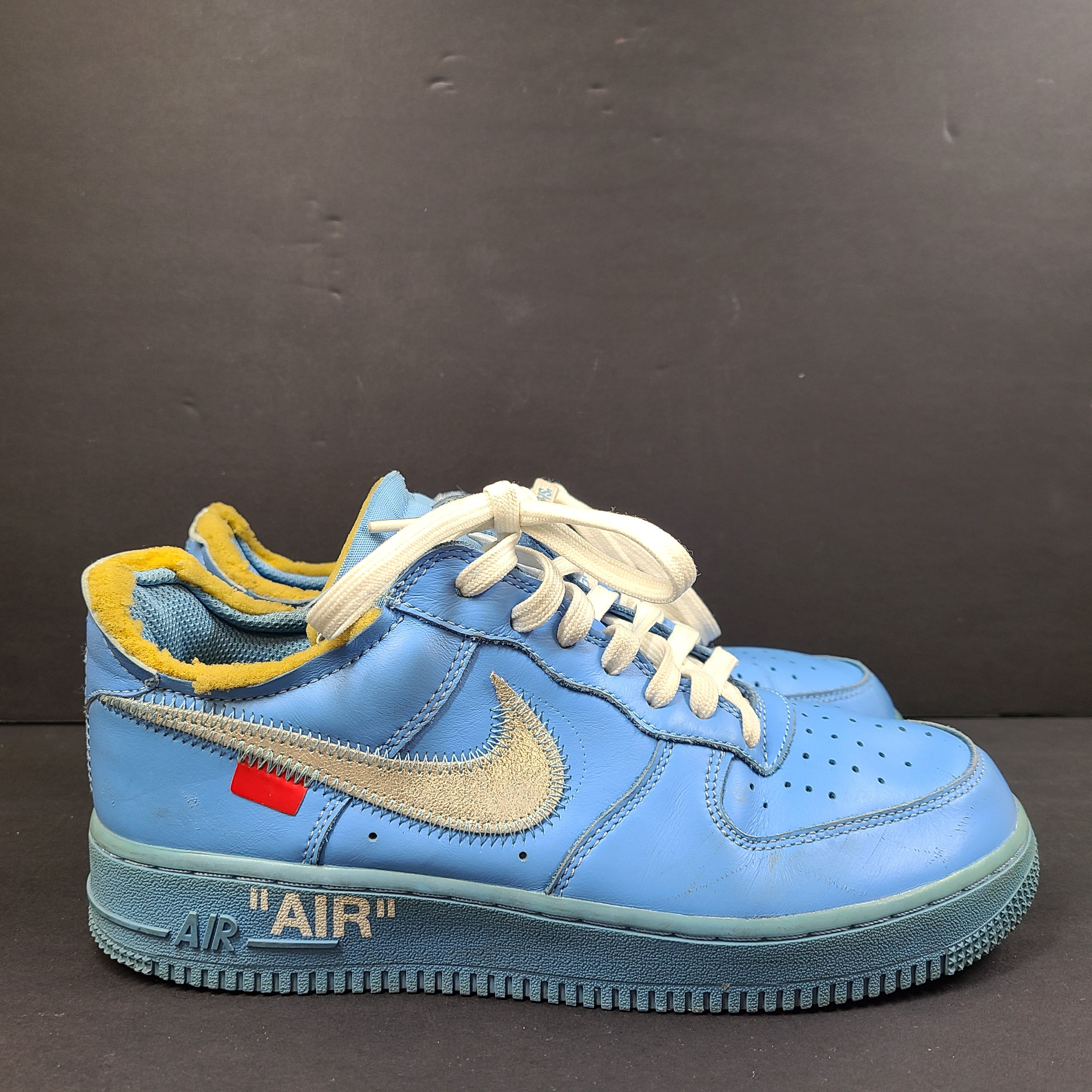 Nike Air Force 1 low-top sneakers in blue and yellow, size US 7, featuring "SHOELACES" text on the laces and "AIR" on the sole.