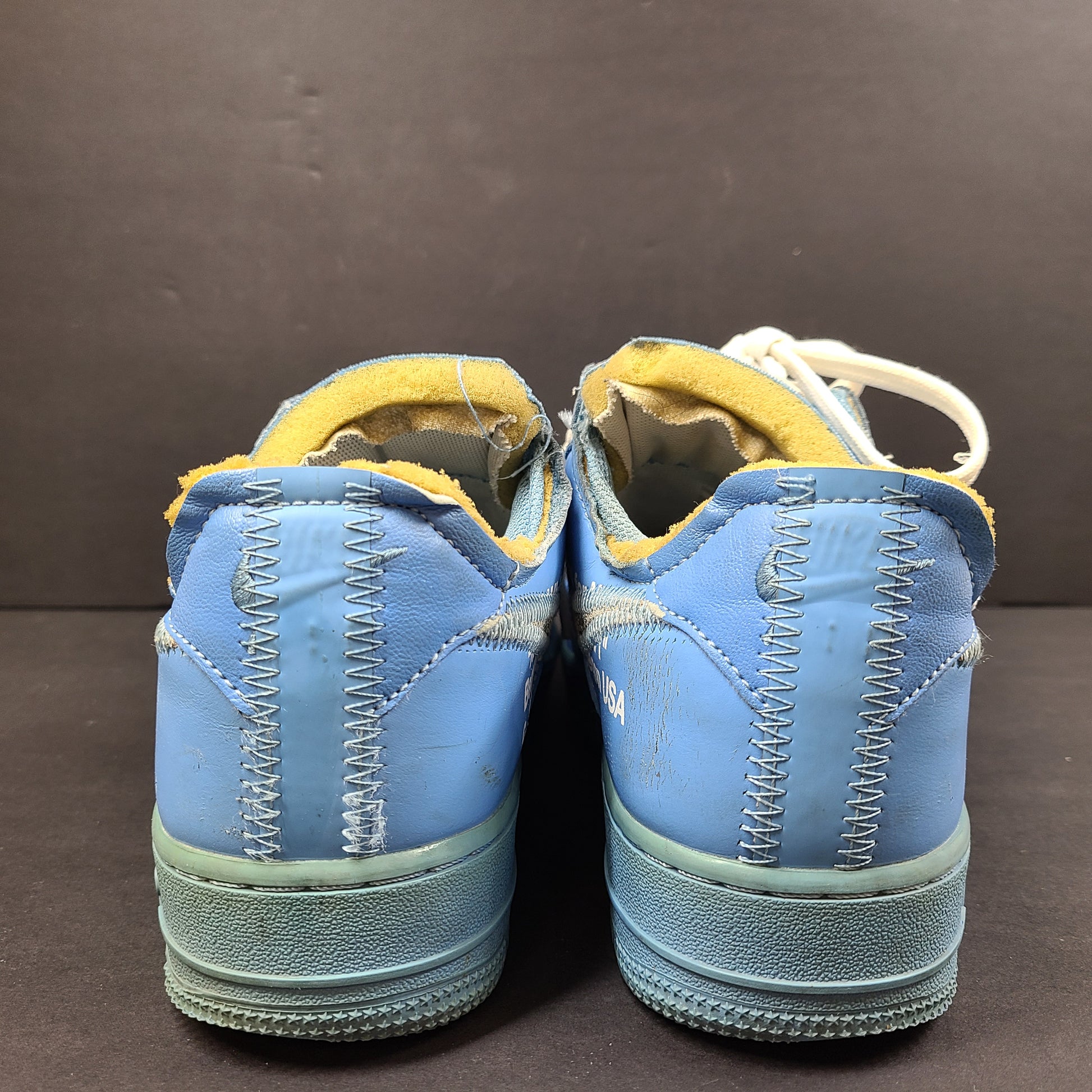 Nike Air Force 1 low-top sneakers in blue and yellow, size US 7, featuring "SHOELACES" text on the laces and "AIR" on the sole.