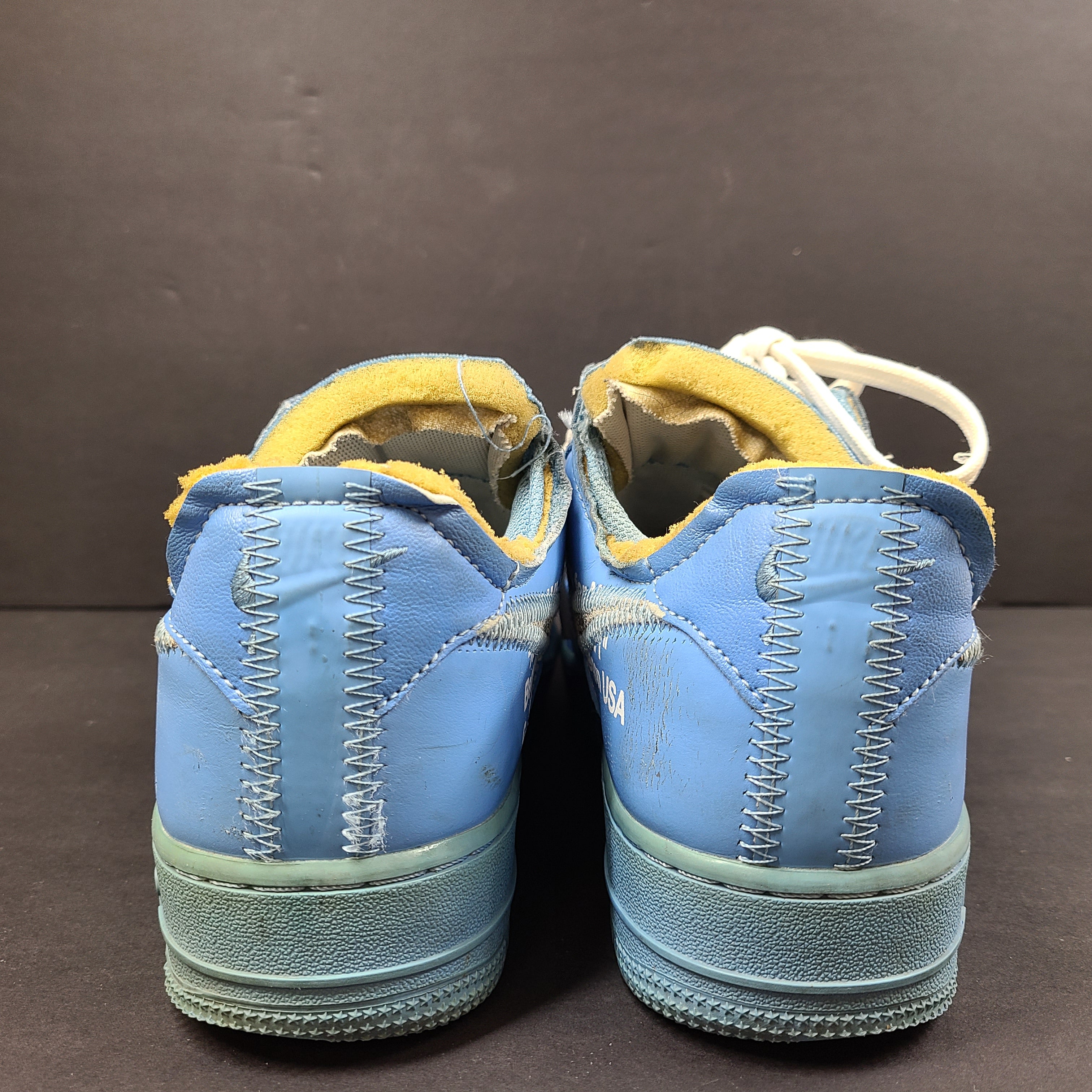 Nike Air Force 1 low-top sneakers in blue and yellow, size US 7, featuring "SHOELACES" text on the laces and "AIR" on the sole.