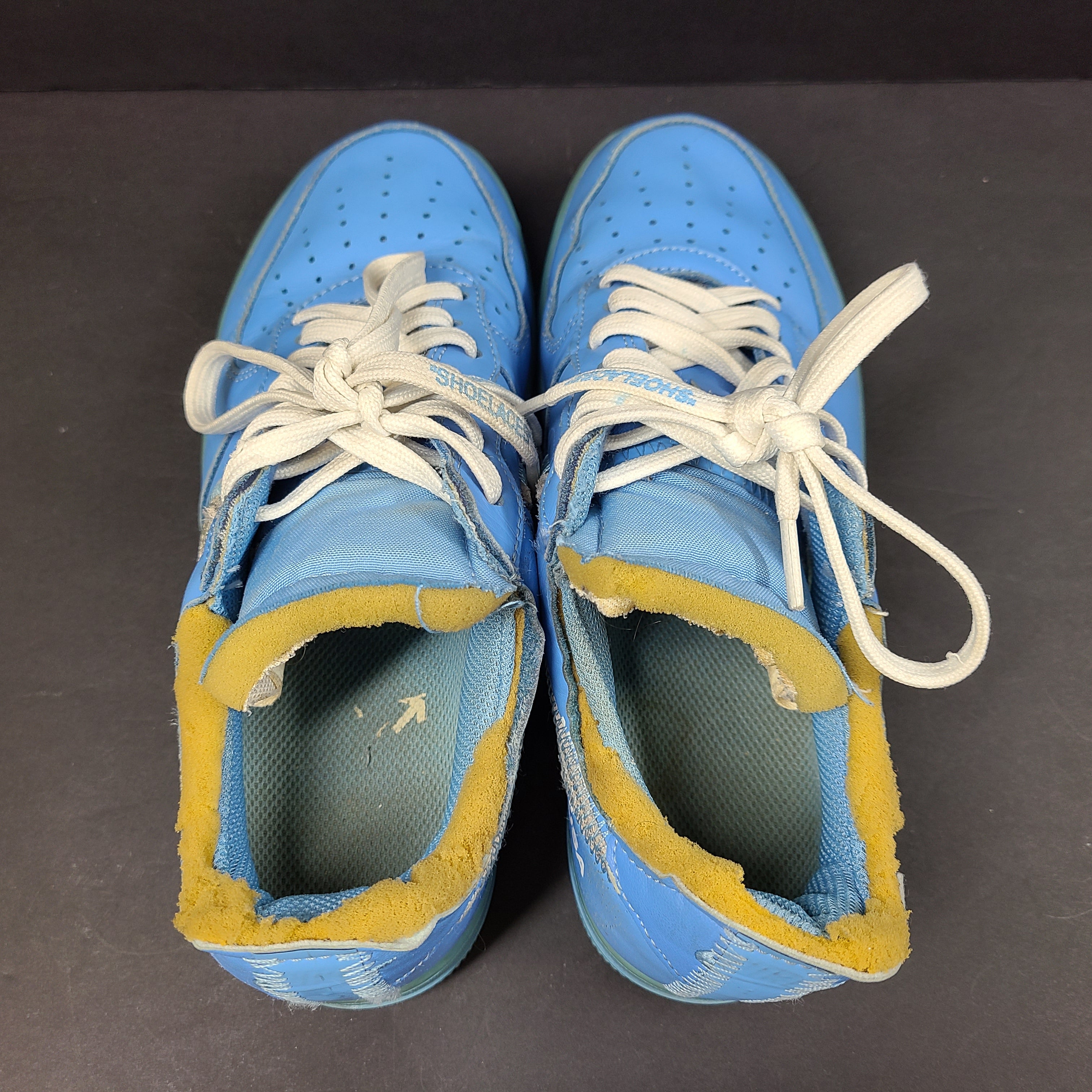 Nike Air Force 1 low-top sneakers in blue and yellow, size US 7, featuring "SHOELACES" text on the laces and "AIR" on the sole.