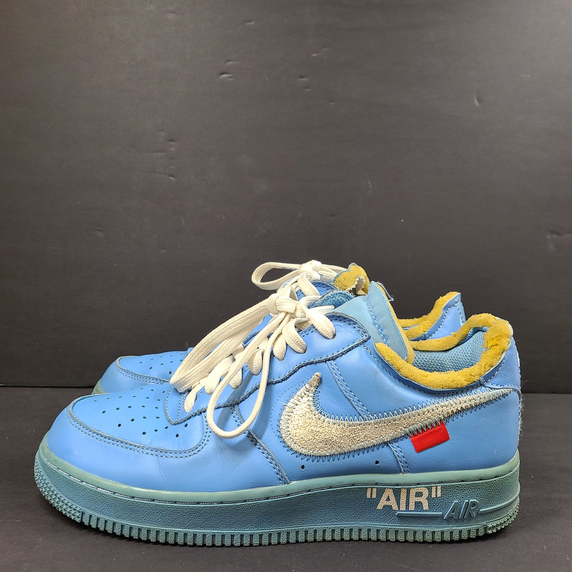 Nike Air Force 1 low-top sneakers in blue and yellow, size US 7, featuring "SHOELACES" text on the laces and "AIR" on the sole.
