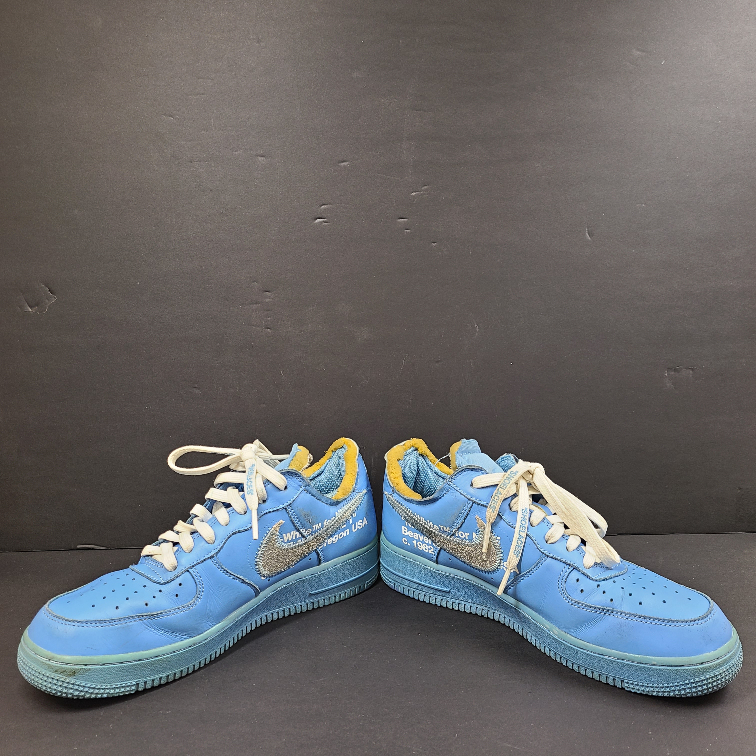 Nike Air Force 1 low-top sneakers in blue and yellow, size US 7, featuring "SHOELACES" text on the laces and "AIR" on the sole.