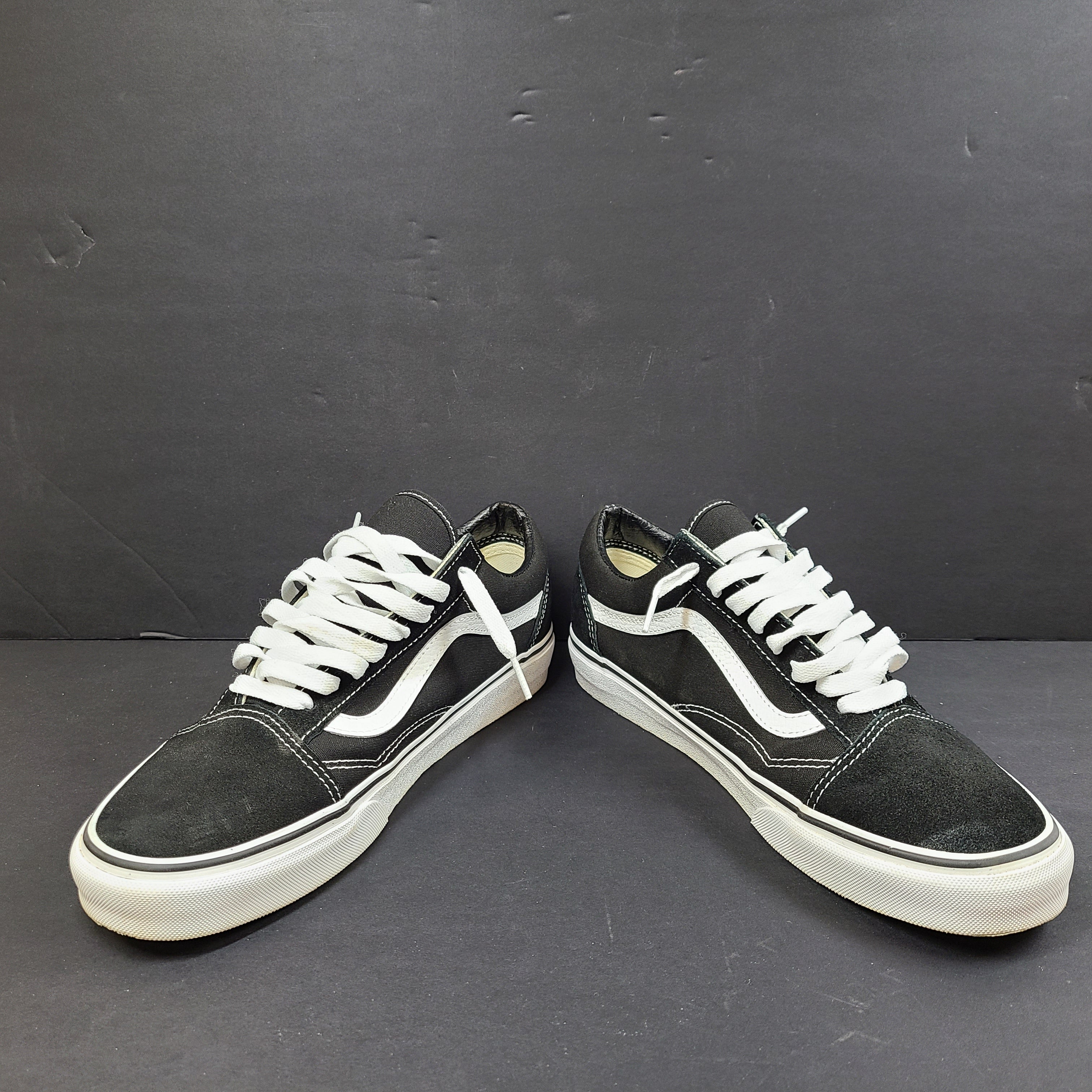 Low-top Vans Old Skool skate shoe in black with a white side stripe and vulcanized sole.