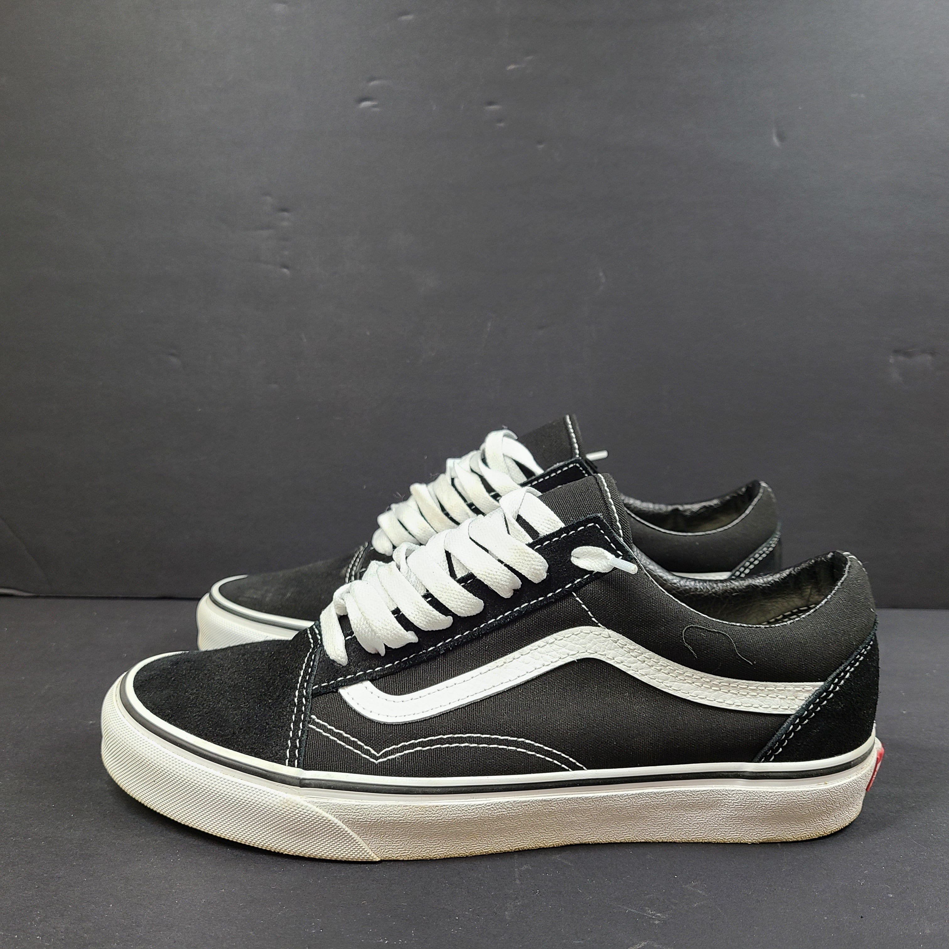 Low-top Vans Old Skool skate shoe in black with a white side stripe and vulcanized sole.