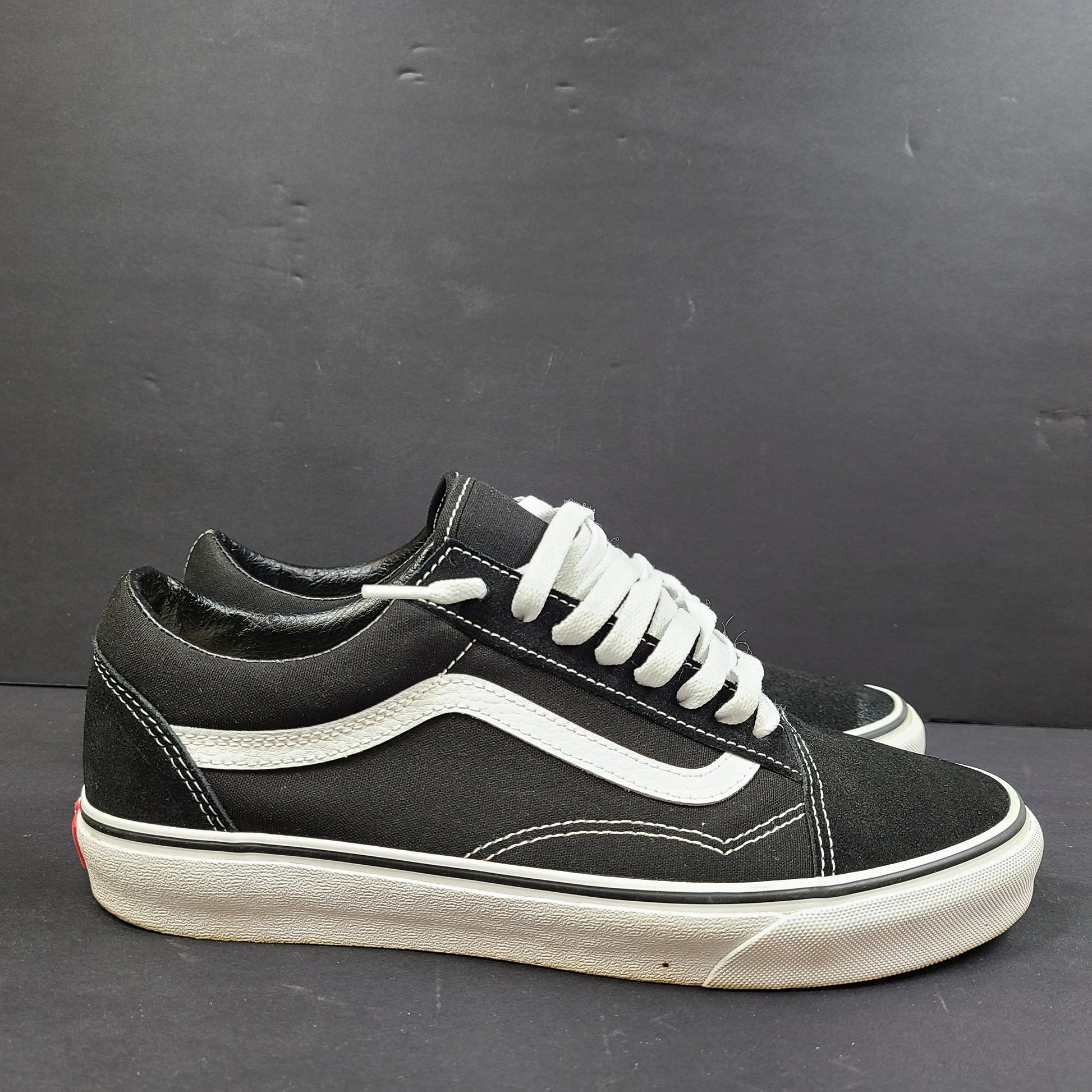 Low-top Vans Old Skool skate shoe in black with a white side stripe and vulcanized sole.