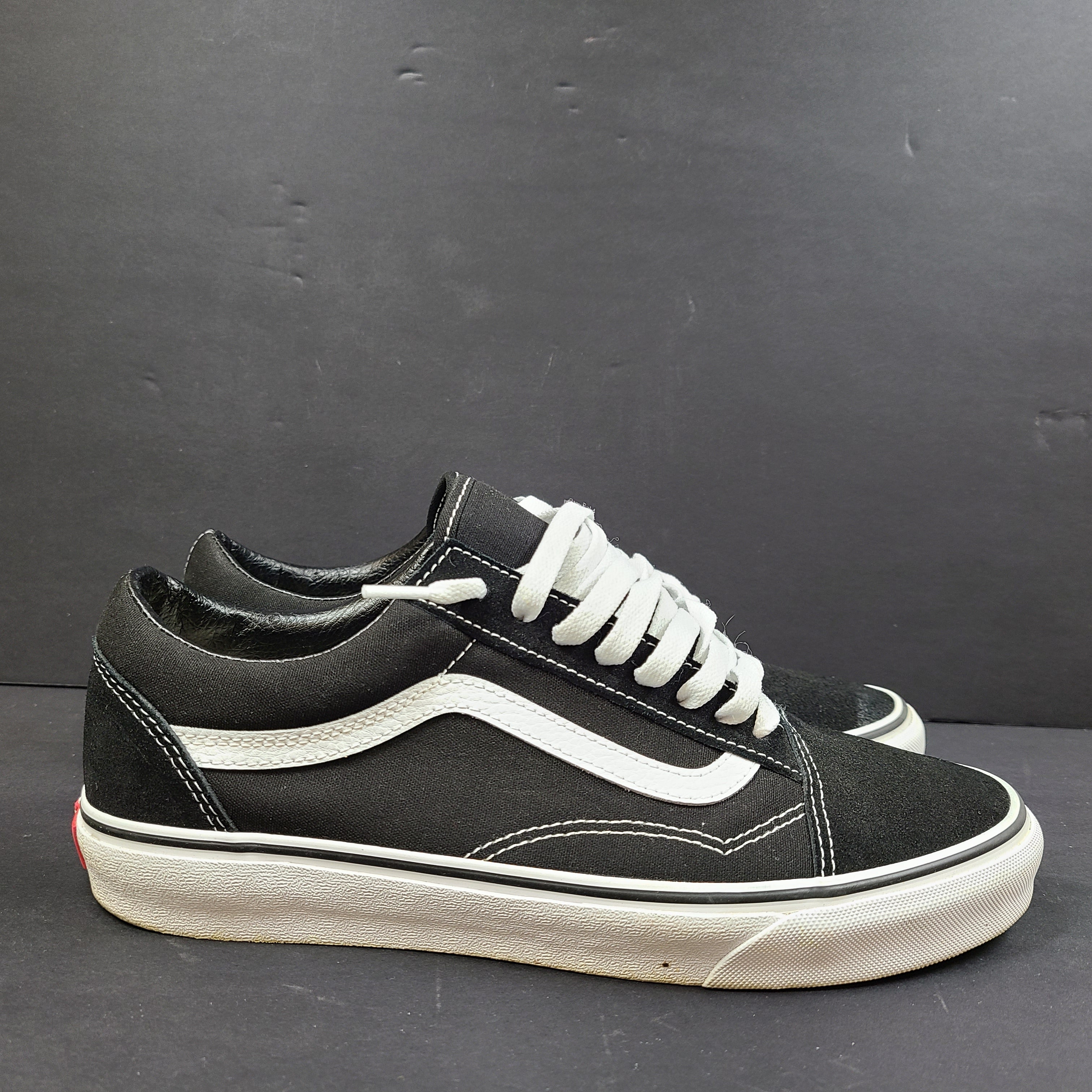 Low-top Vans Old Skool skate shoe in black with a white side stripe and vulcanized sole.