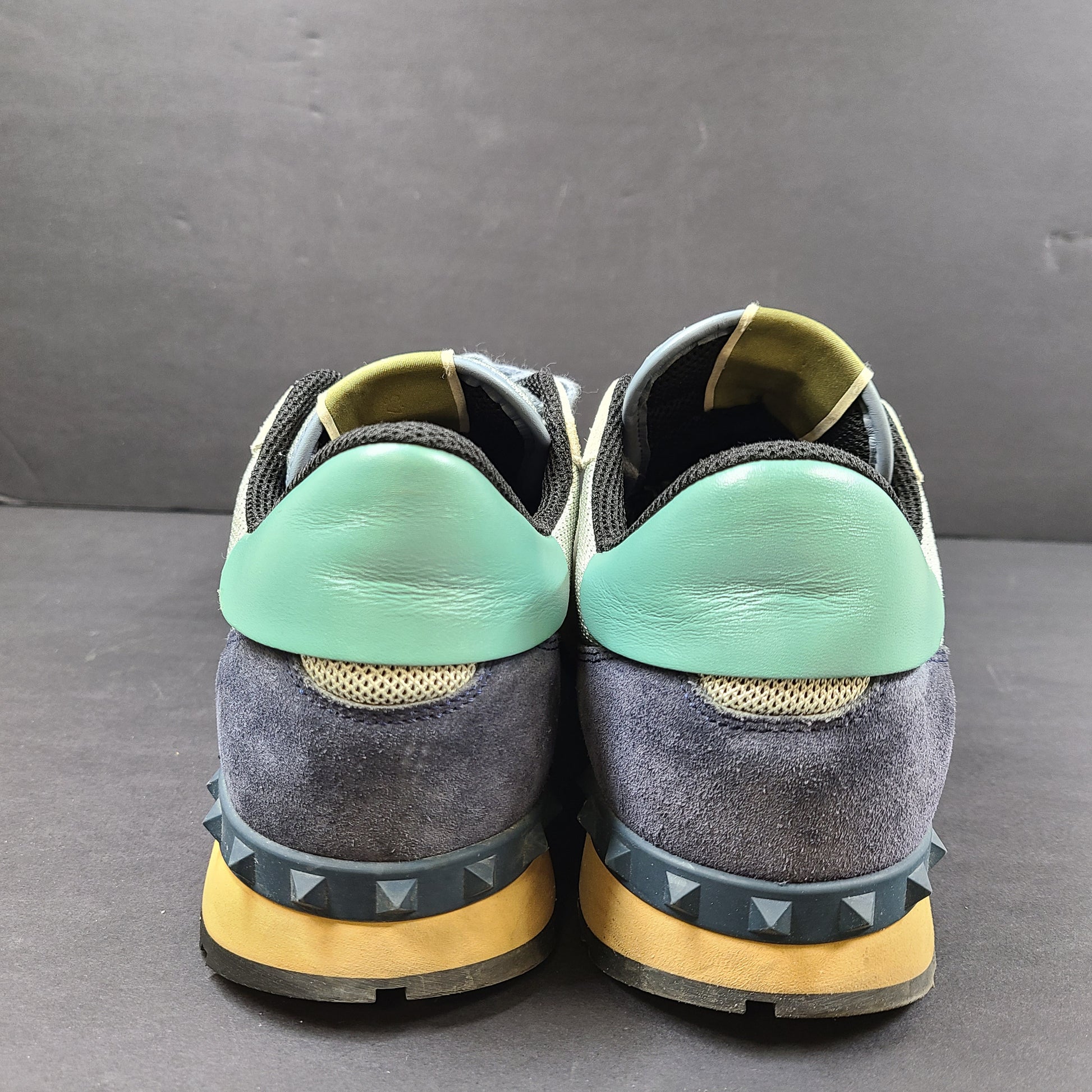 Valentino Garavani low-top sneakers in beige, blue, and green with signature designer branding.
