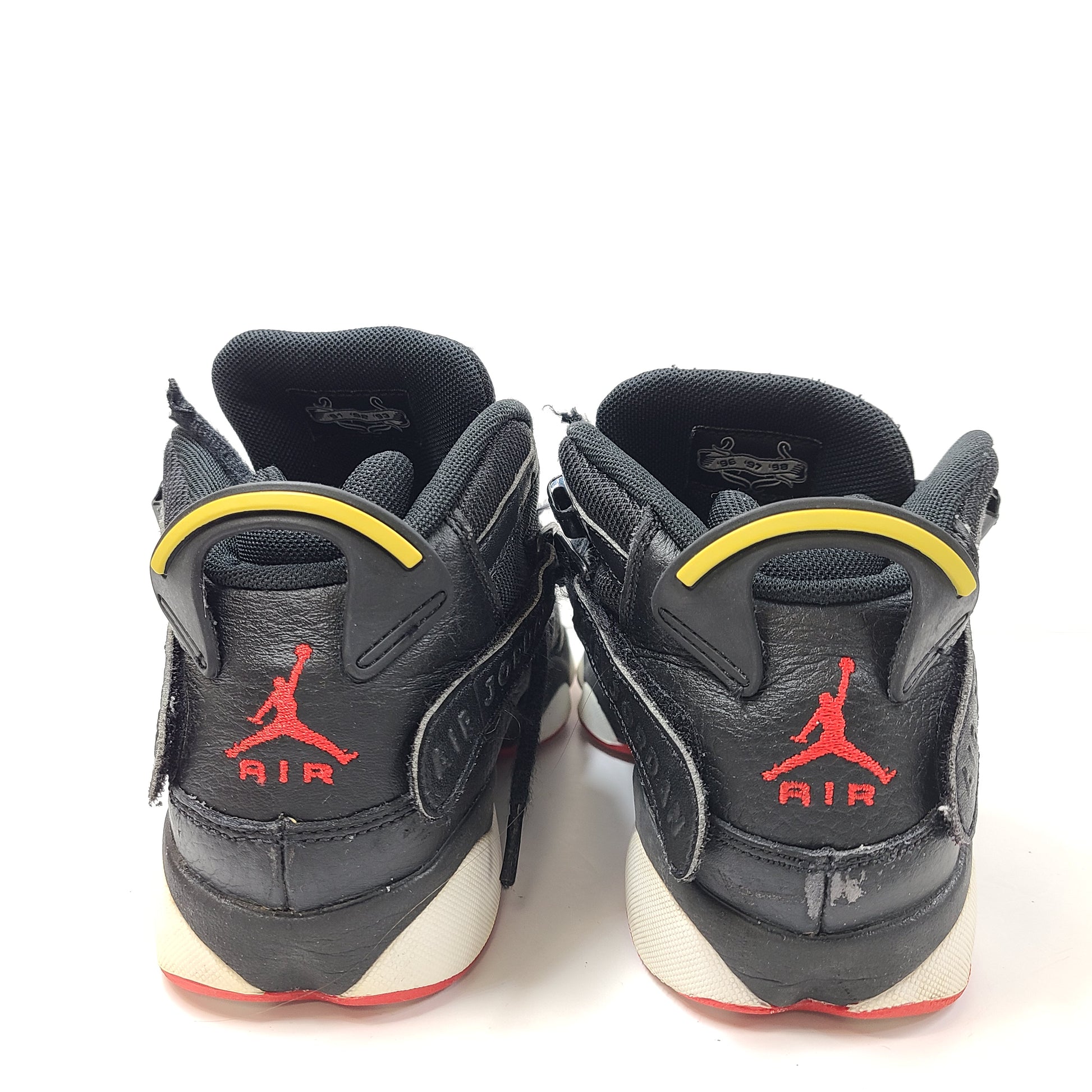 Jordan Air Jordan 6 Rings youth sneakers in black, red and yellow with light scuffs and mildly discolored soles.