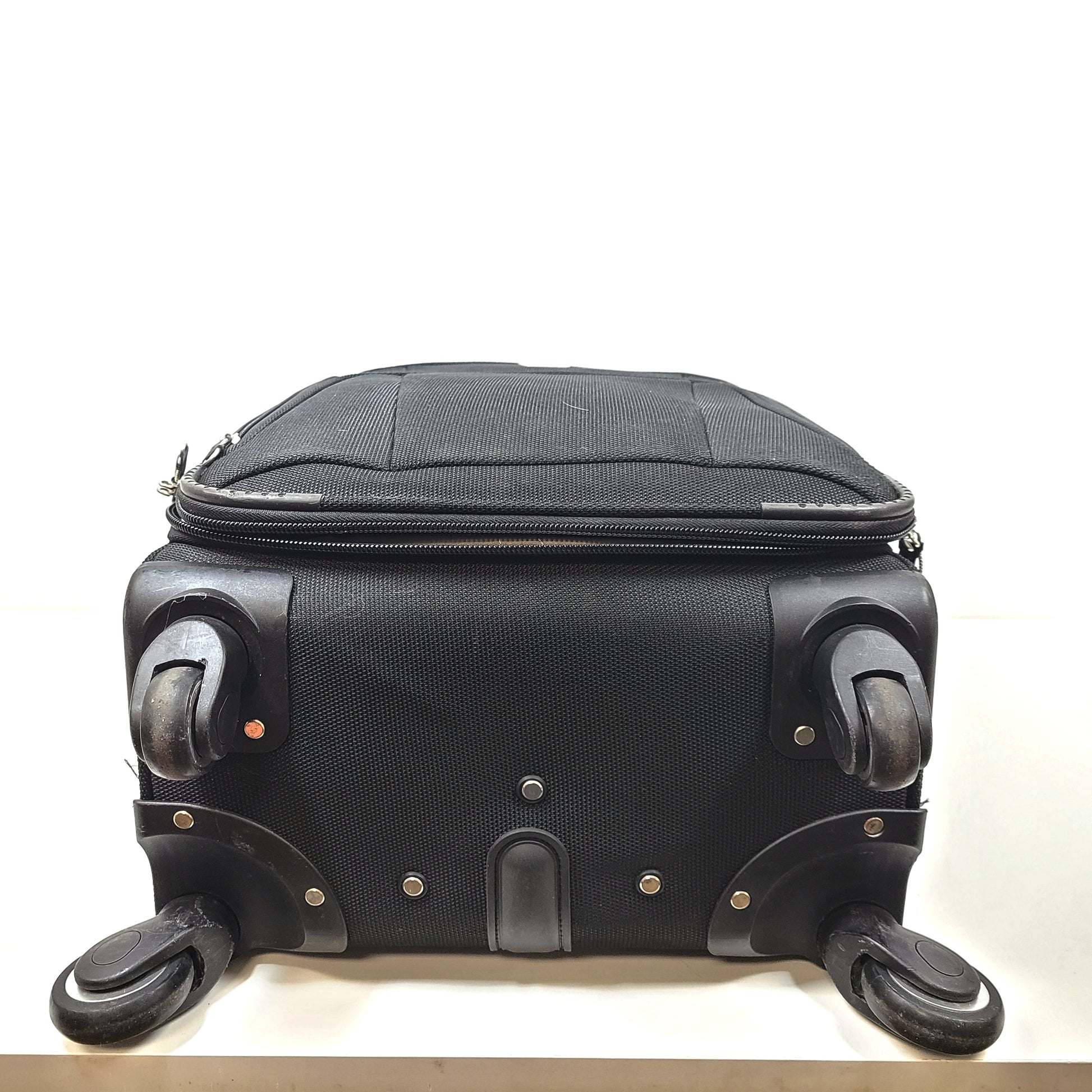 Black Samsonite suitcase QC-002454 with minor scuff marks and labeled material composition.