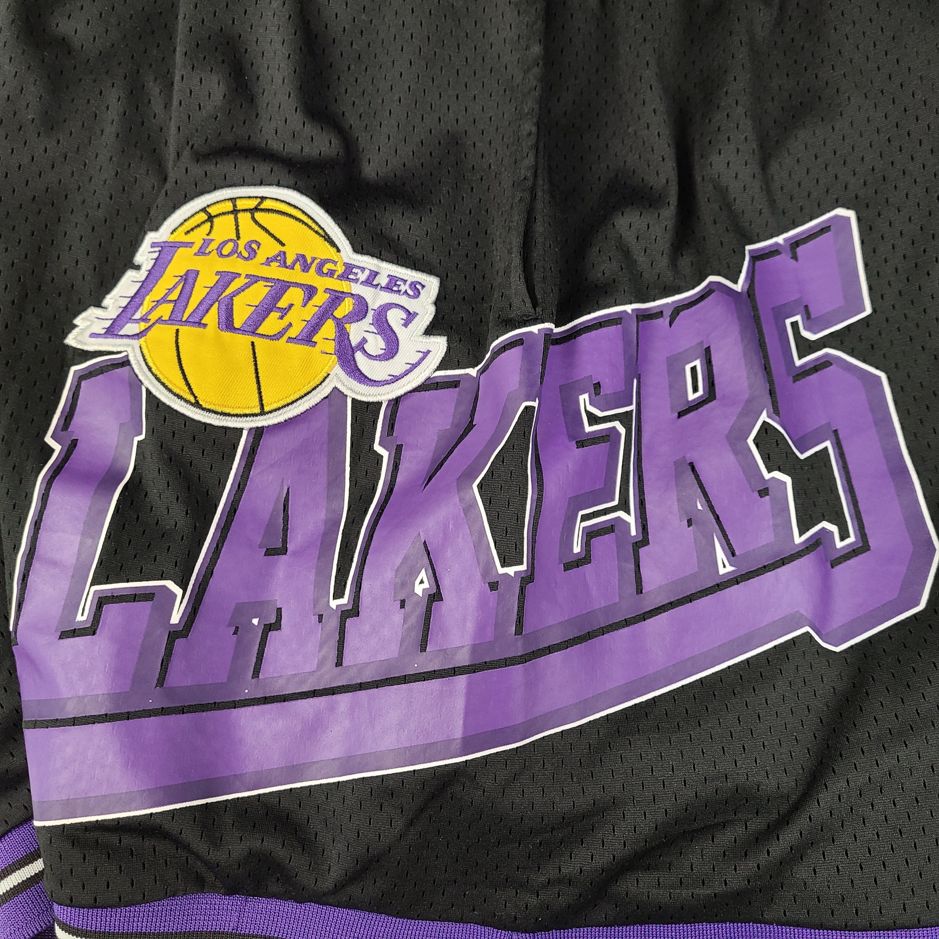 Black and purple Los Angeles Lakers basketball shorts by Ultra Game with team and NBA logos.