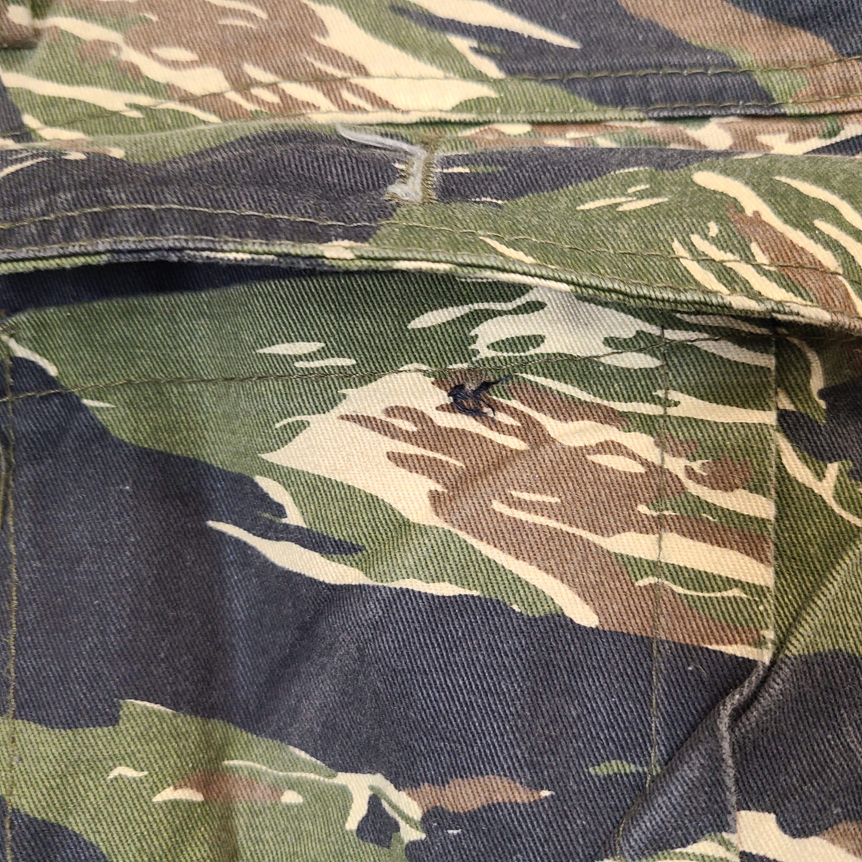 Black camouflage cargo pants in size 30 with multiple utility pockets and a rugged workwear cut.