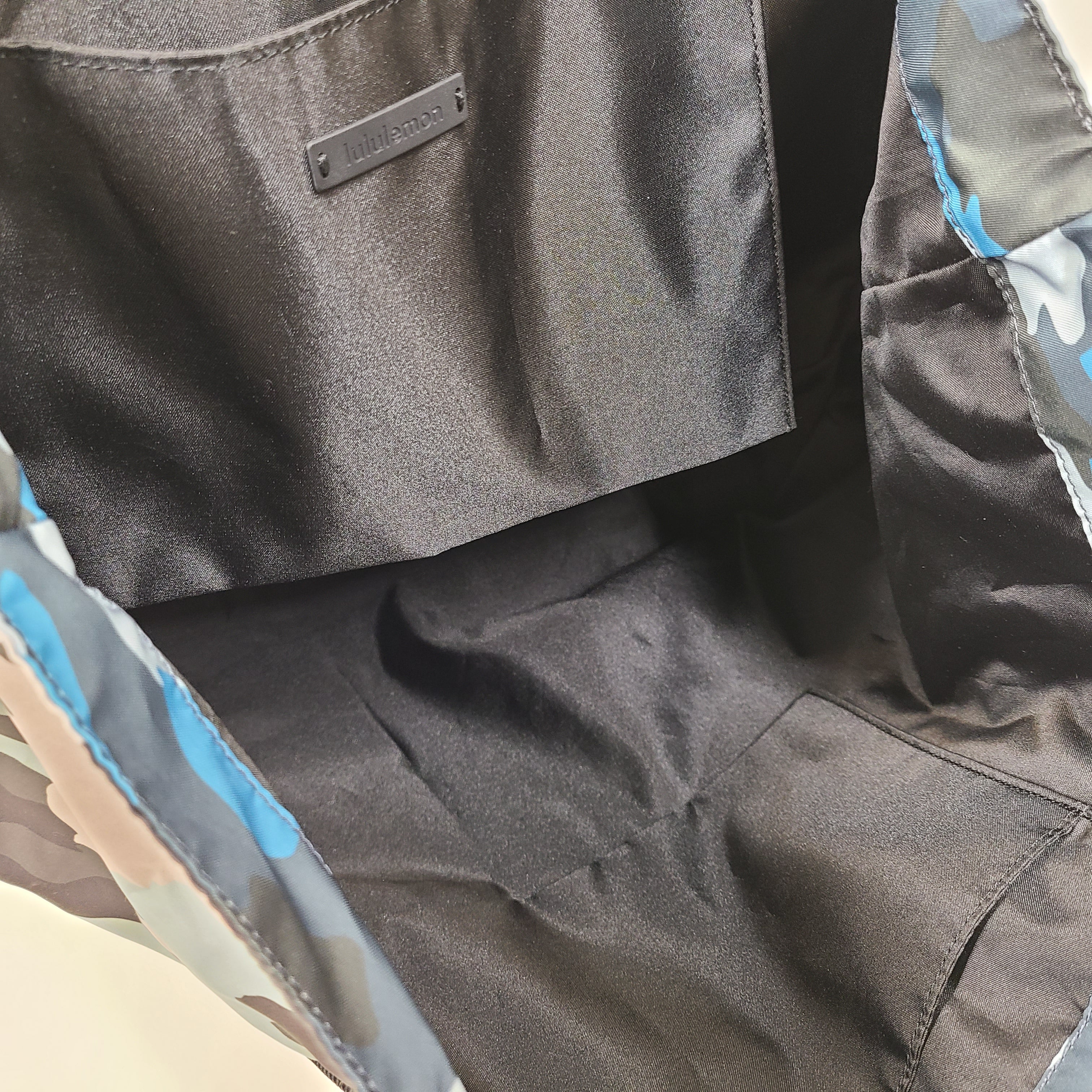 Multicolor Lululemon camouflage tote with pink, brown, green and blue panels and an internal label reading "items of importance".