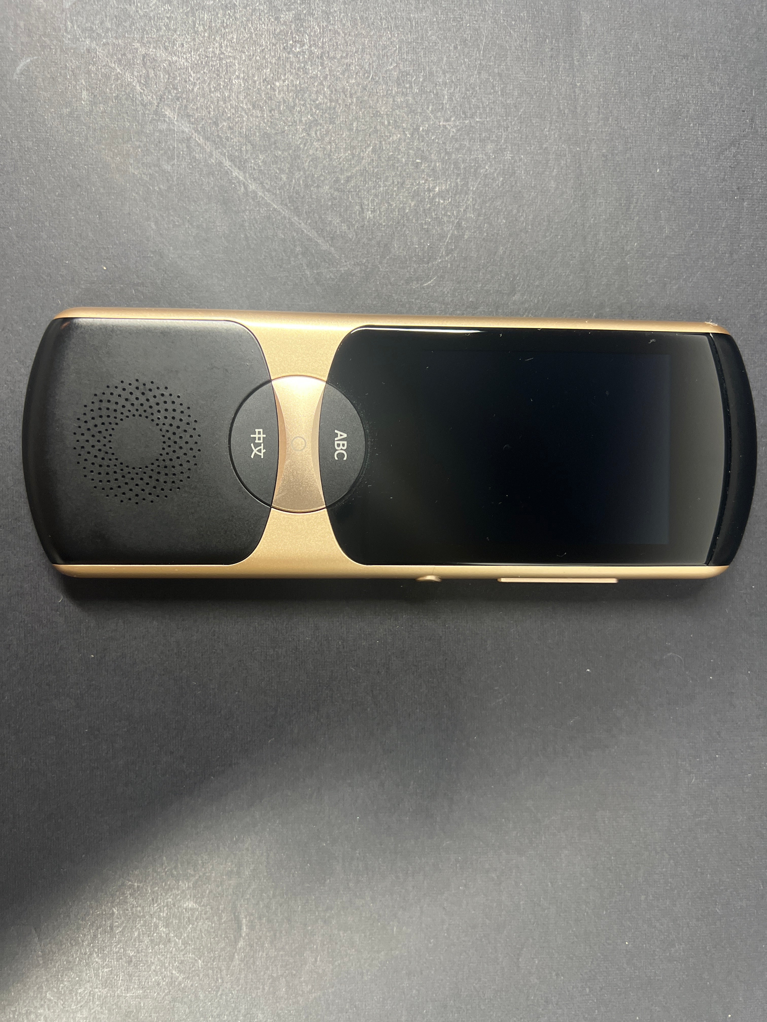 Black and gold iFLYTEK AIT02 voice translator showing front and back with buttons and display screen visible