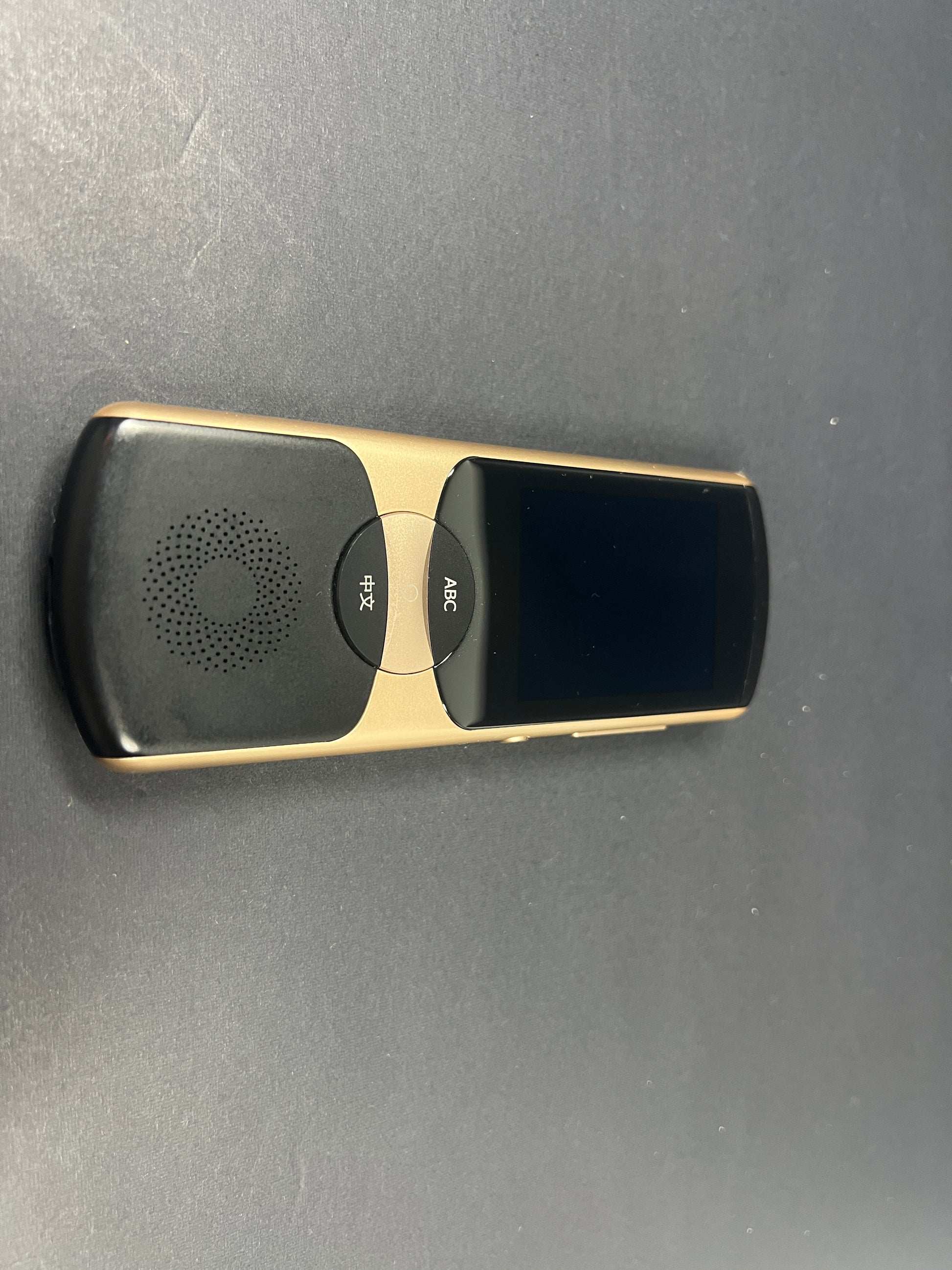 Black and gold iFLYTEK AIT02 voice translator showing front and back with buttons and display screen visible