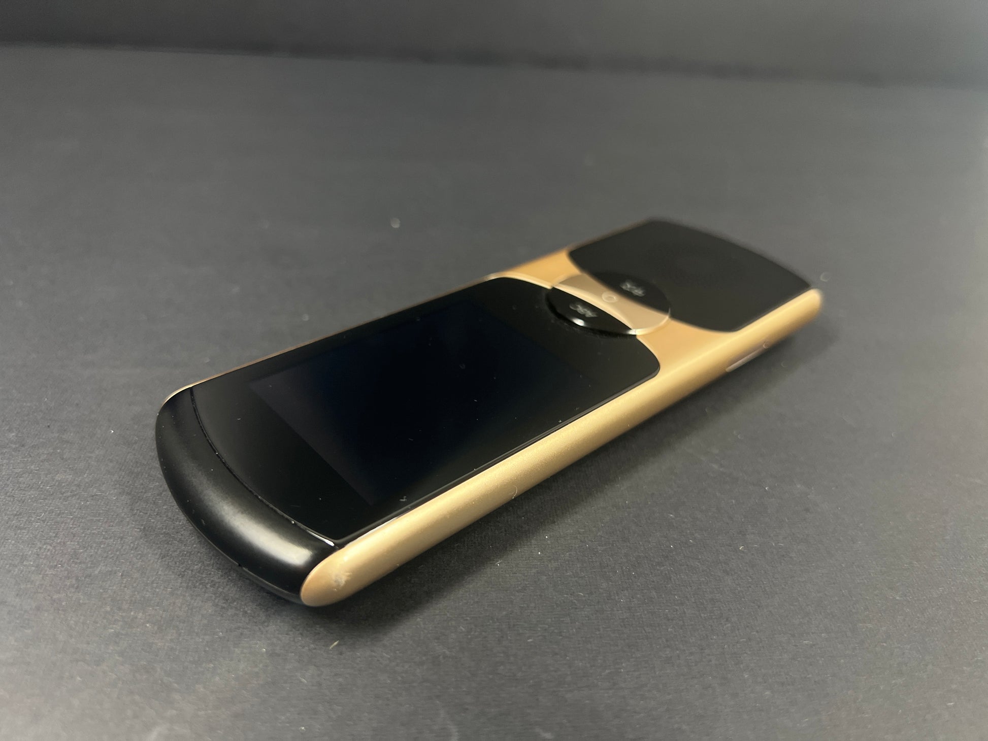 Black and gold iFLYTEK AIT02 voice translator showing front and back with buttons and display screen visible