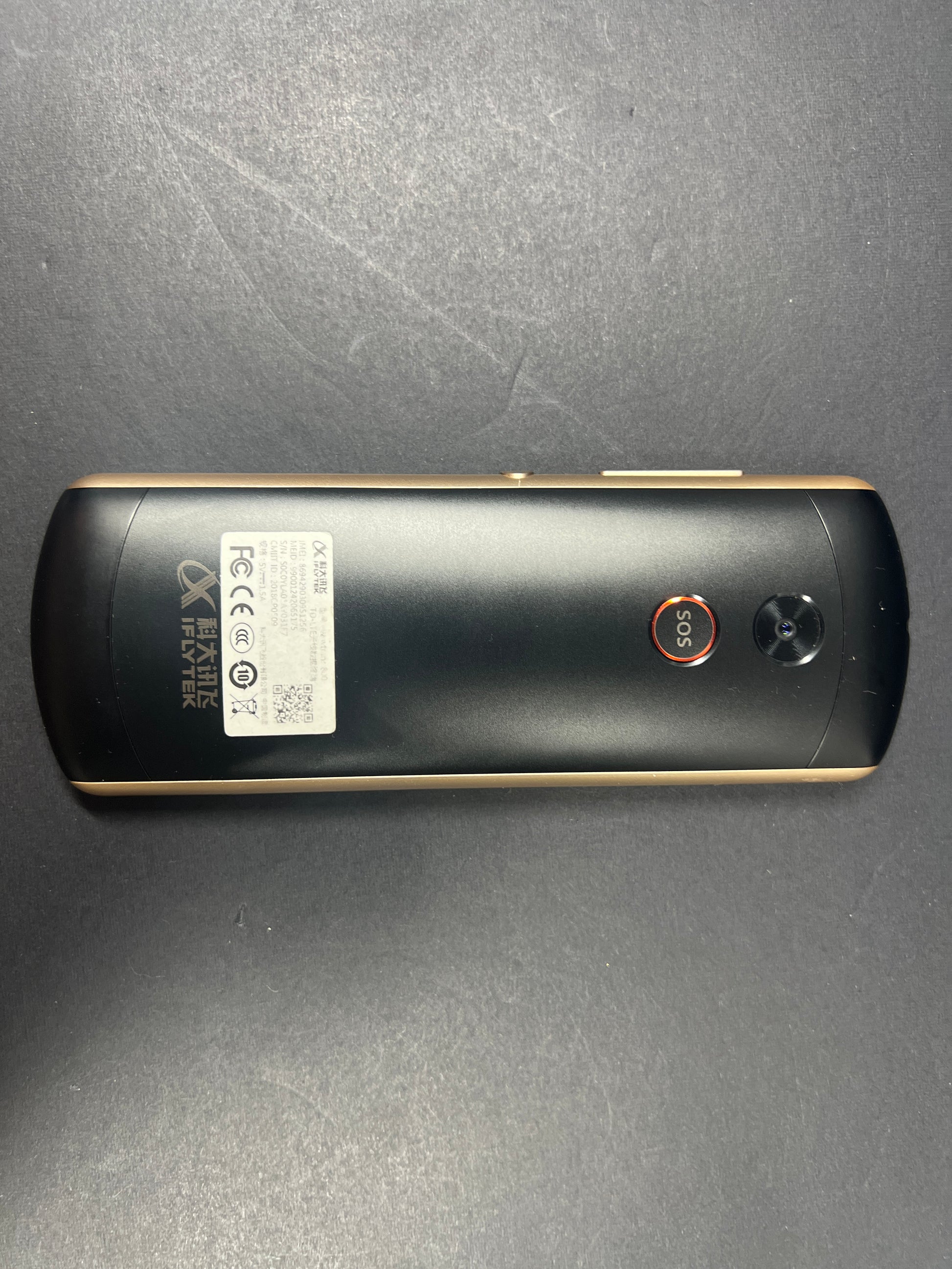 Black and gold iFLYTEK AIT02 voice translator showing front and back with buttons and display screen visible