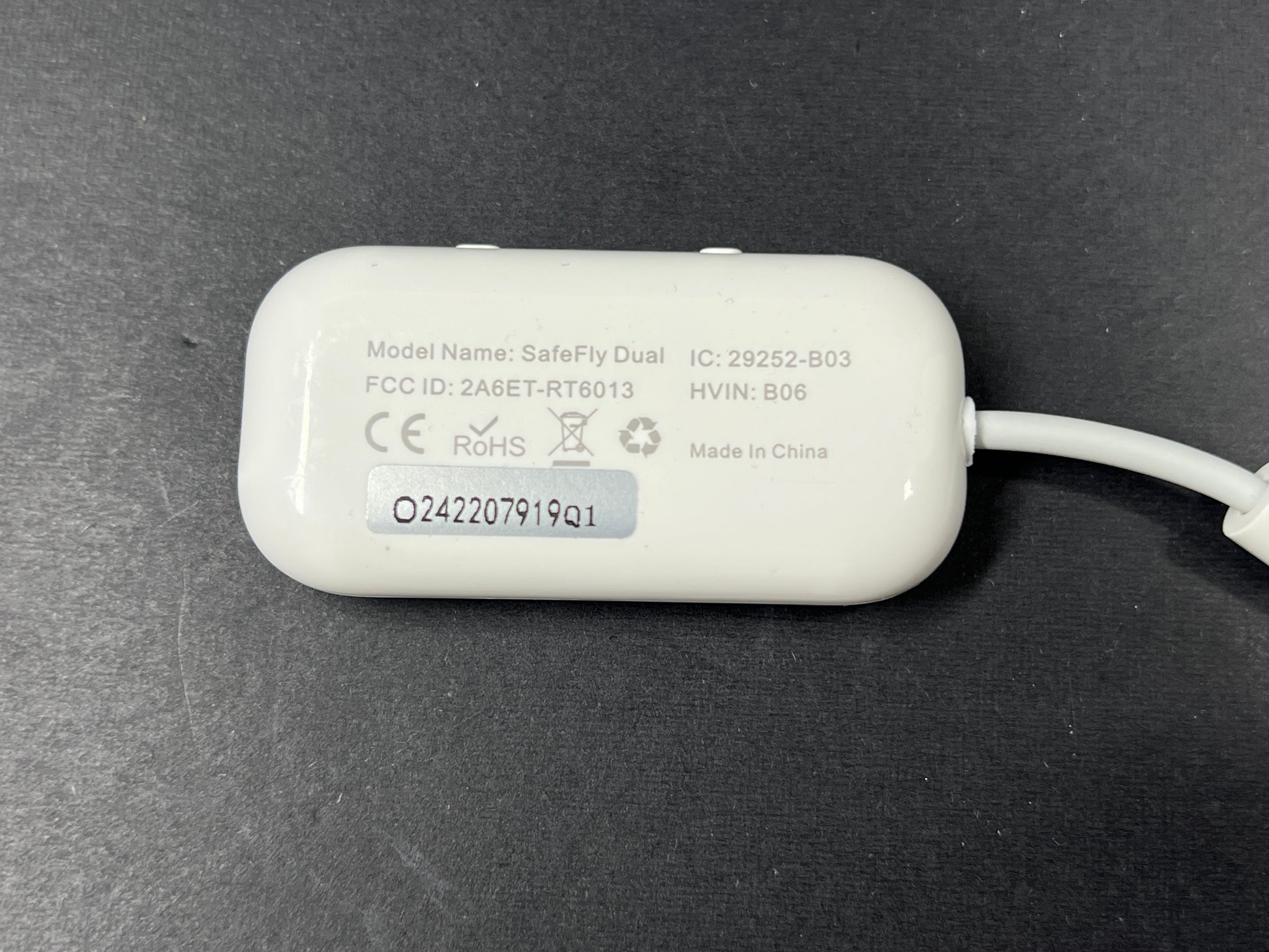 Small white Bluetooth audio adapter with display and 3.5mm jack designed for wireless headphone use on planes