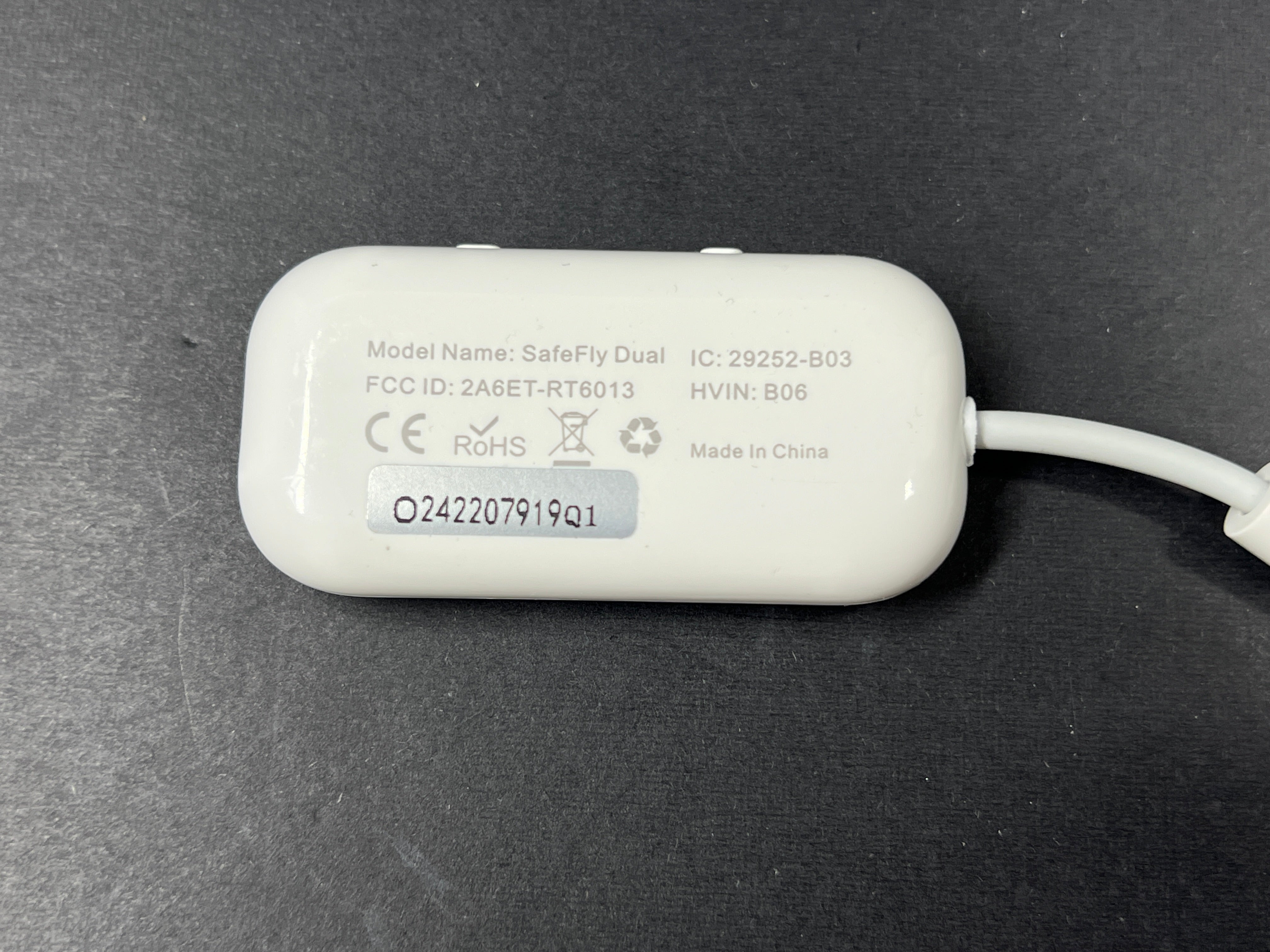 Small white Bluetooth audio adapter with display and 3.5mm jack designed for wireless headphone use on planes