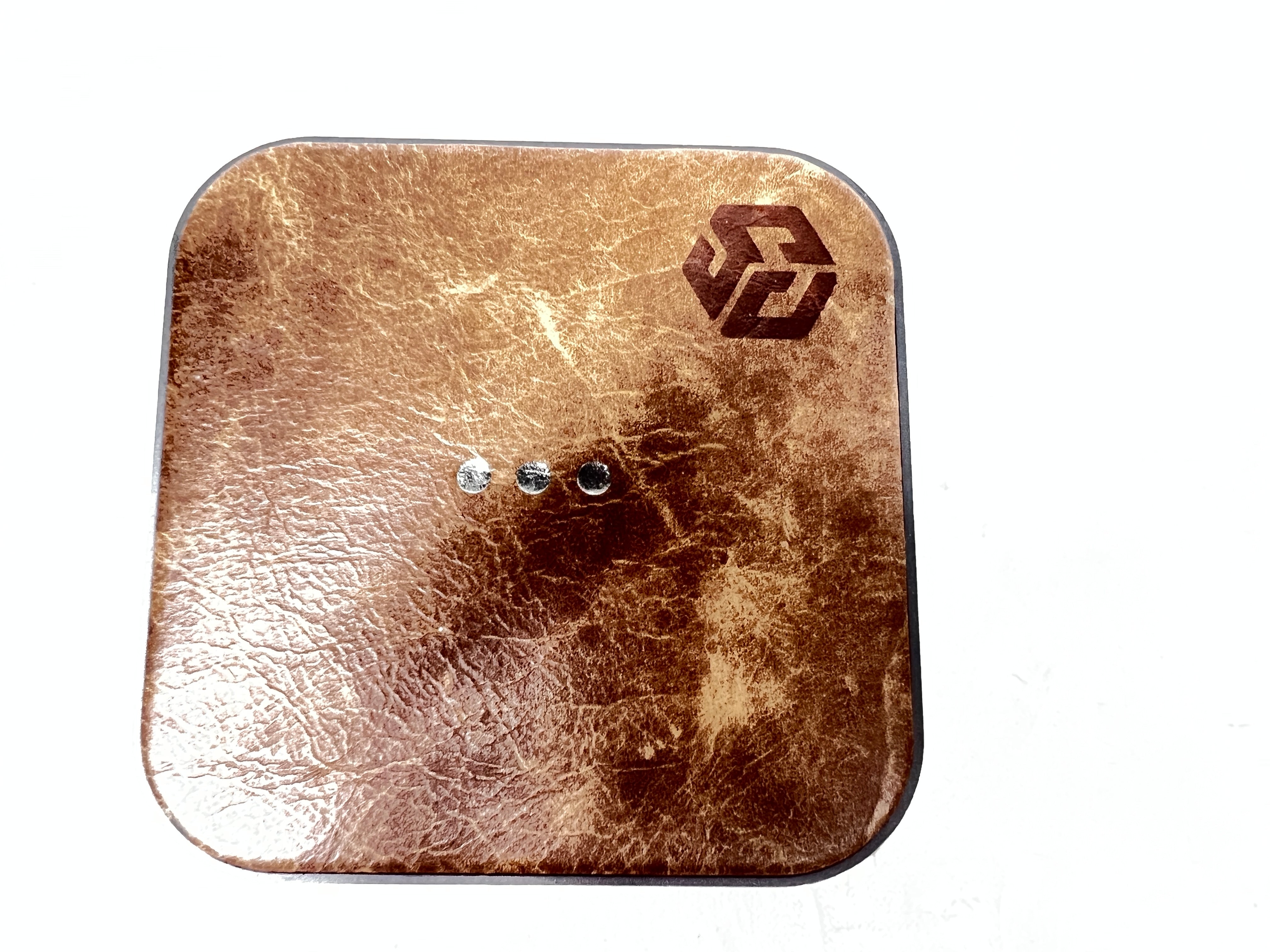 Leather-top Courant wireless charging pad with USB-C input, brown with visible wear and LED indicator dots.
