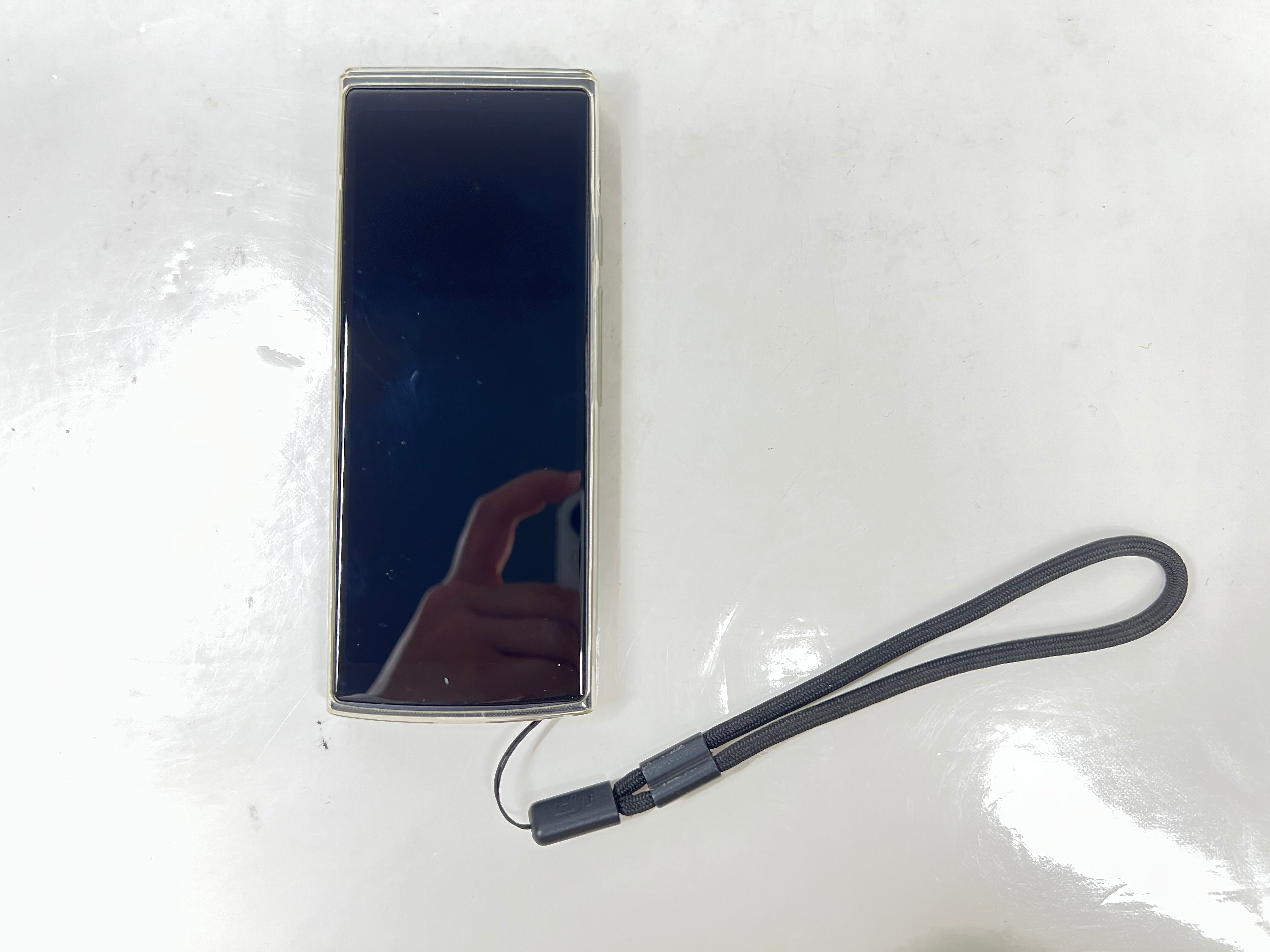 iFlytek Translator 4.0 AI device in navy with wrist strap, rear camera, and side buttons shown