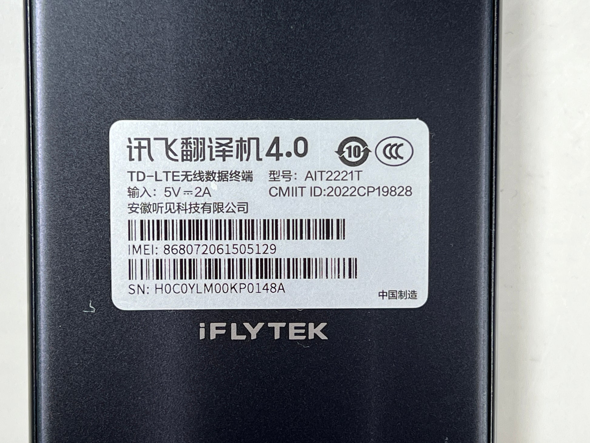 iFlytek Translator 4.0 AI device in navy with wrist strap, rear camera, and side buttons shown