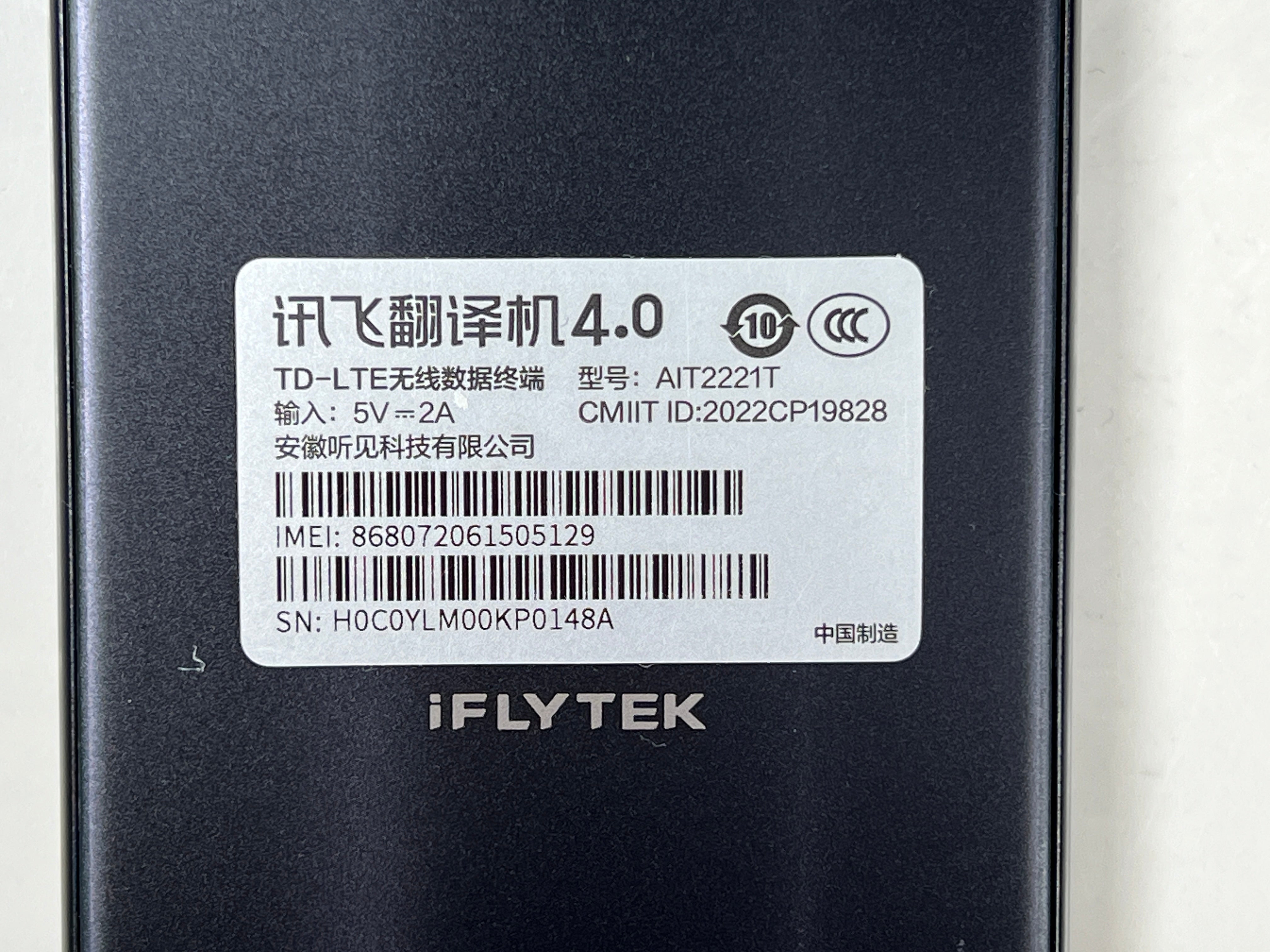 iFlytek Translator 4.0 AI device in navy with wrist strap, rear camera, and side buttons shown