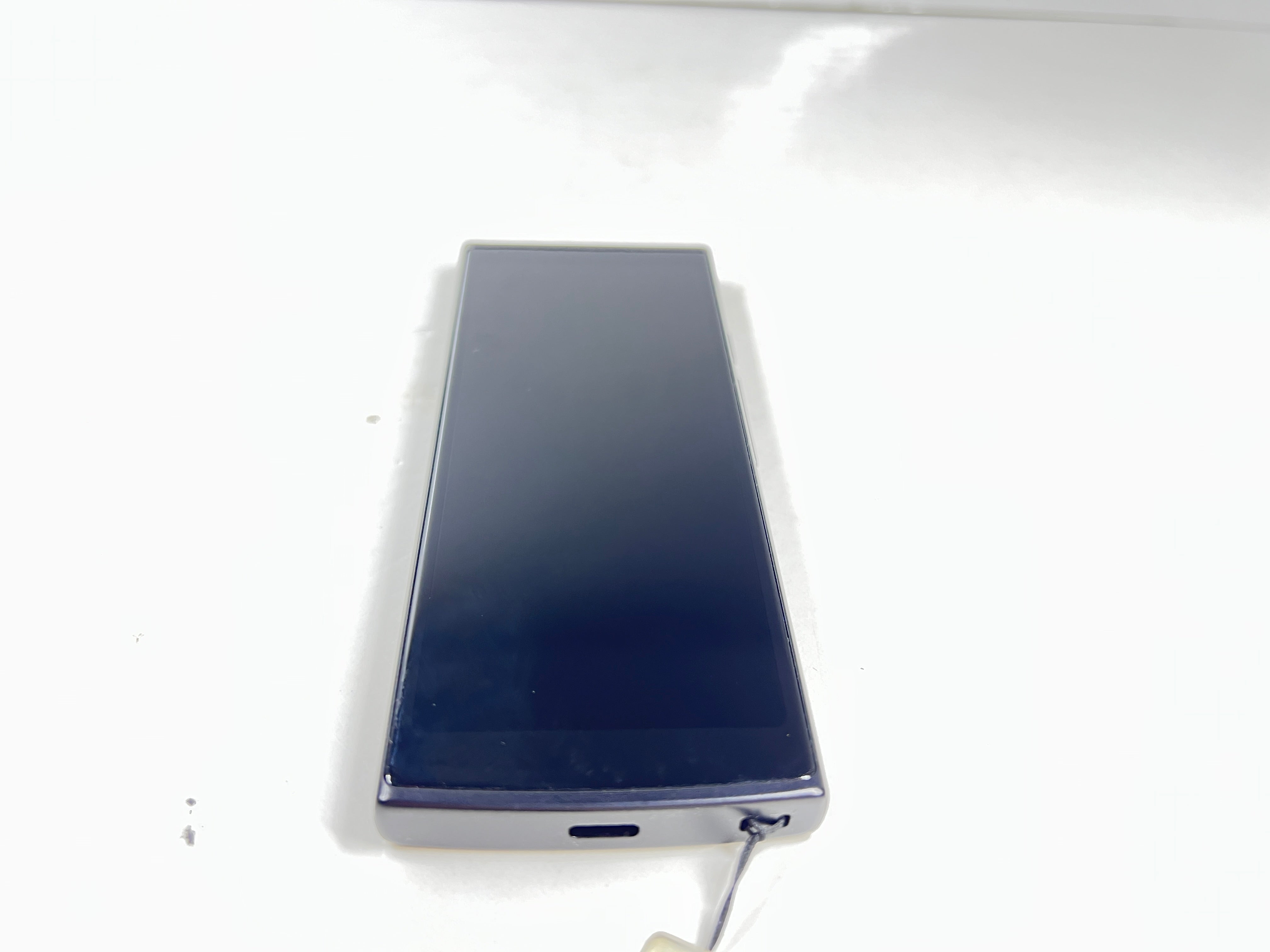 iFlytek Translator 4.0 AI device in navy with wrist strap, rear camera, and side buttons shown