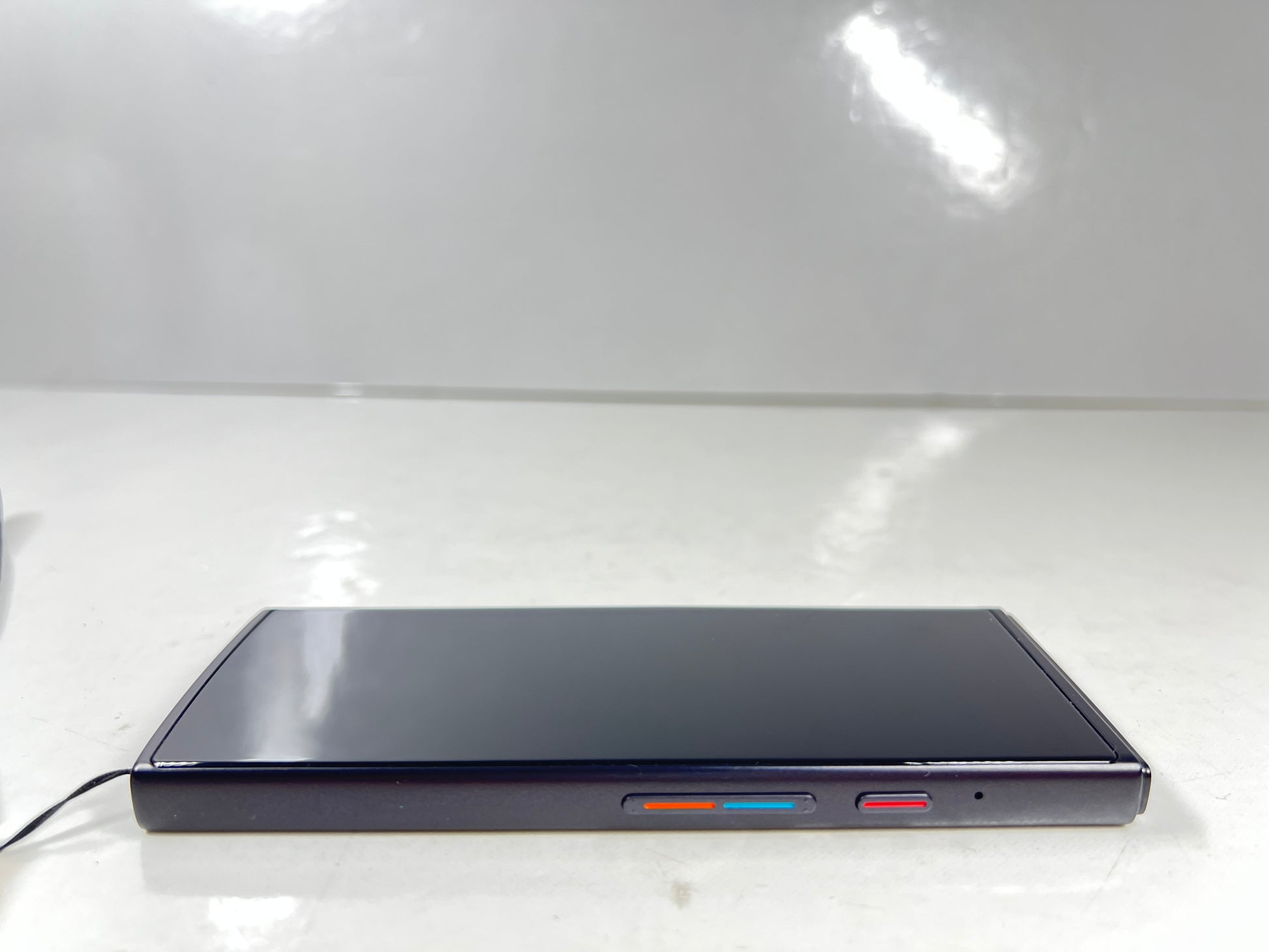 iFlytek Translator 4.0 AI device in navy with wrist strap, rear camera, and side buttons shown