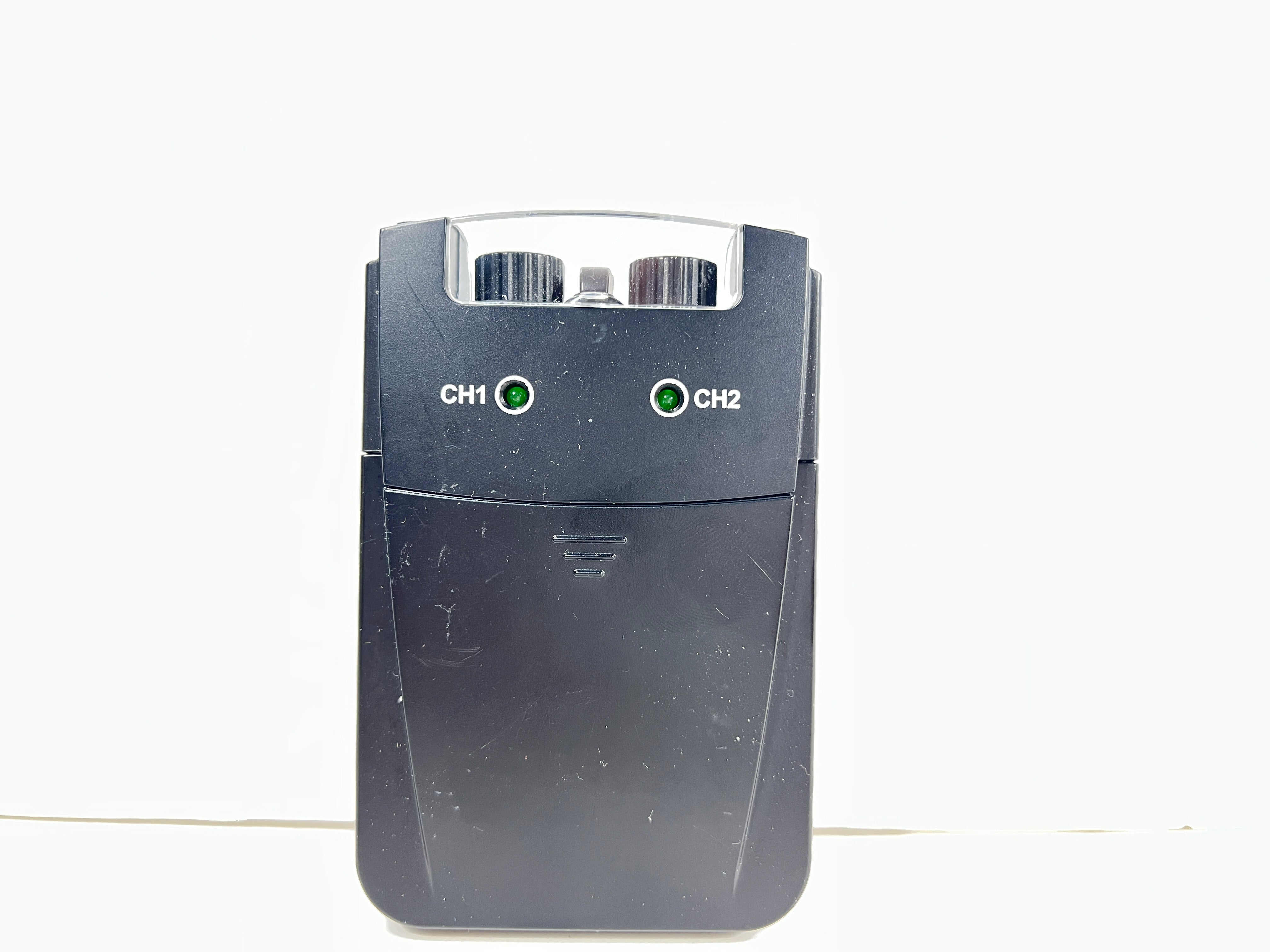 Close-up of black AMG Medical dual-channel TENS unit with belt clip and CH1/CH2 dials