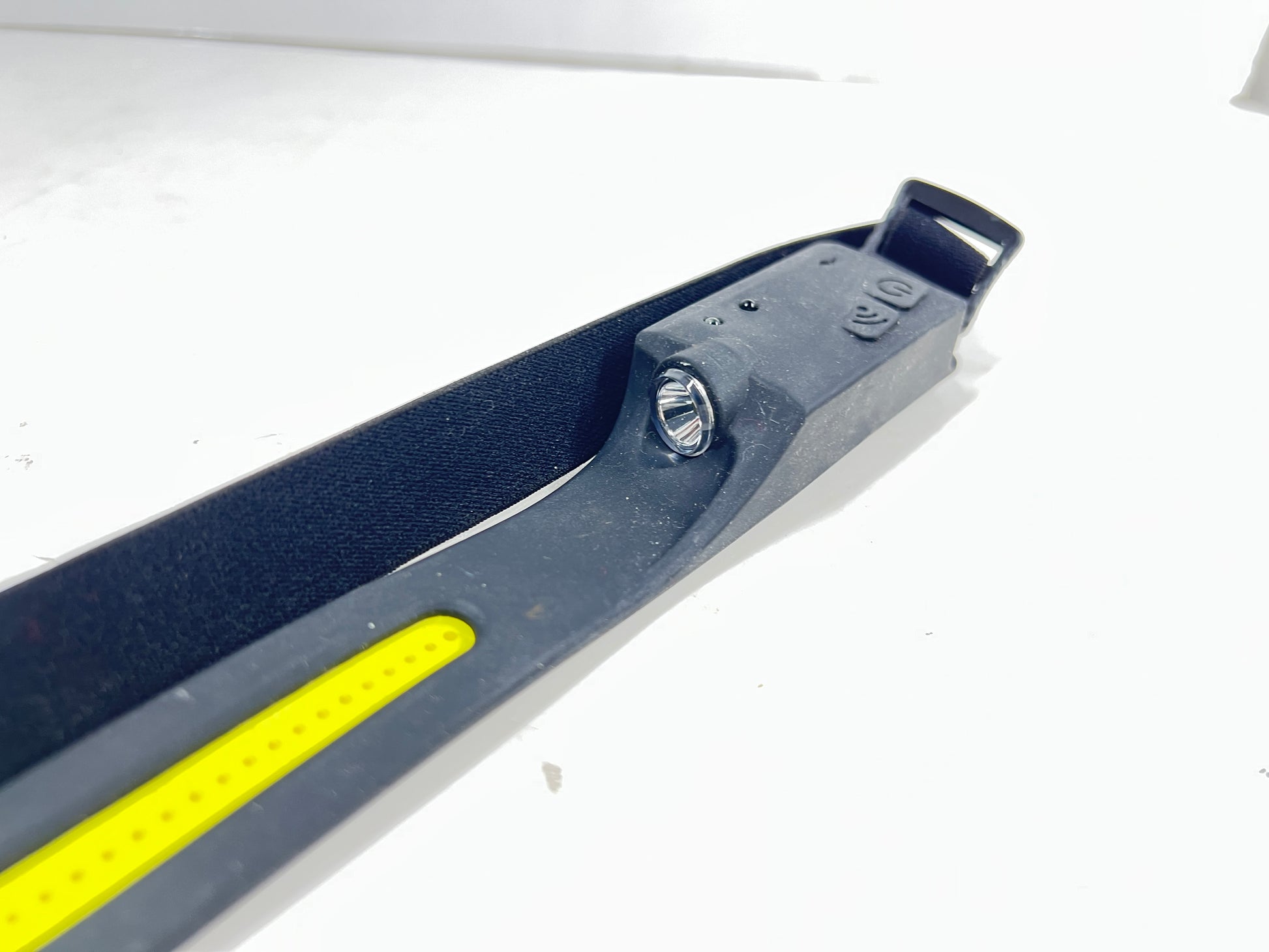 Black and yellow rechargeable headlamp with COB strip and spotlight, shown with adjustable strap and power controls.