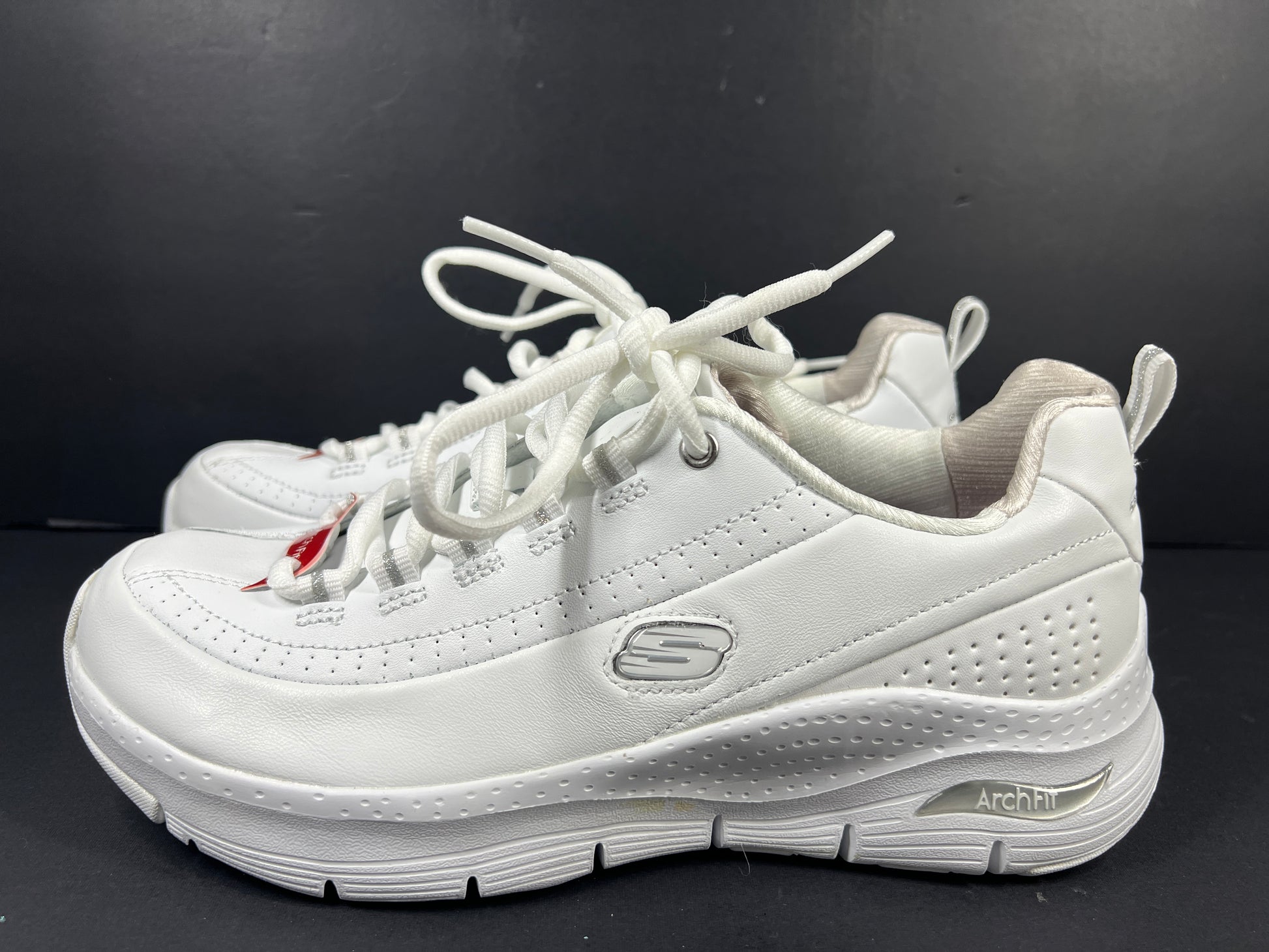 A pair of white Skechers Arch Fit women's sneakers