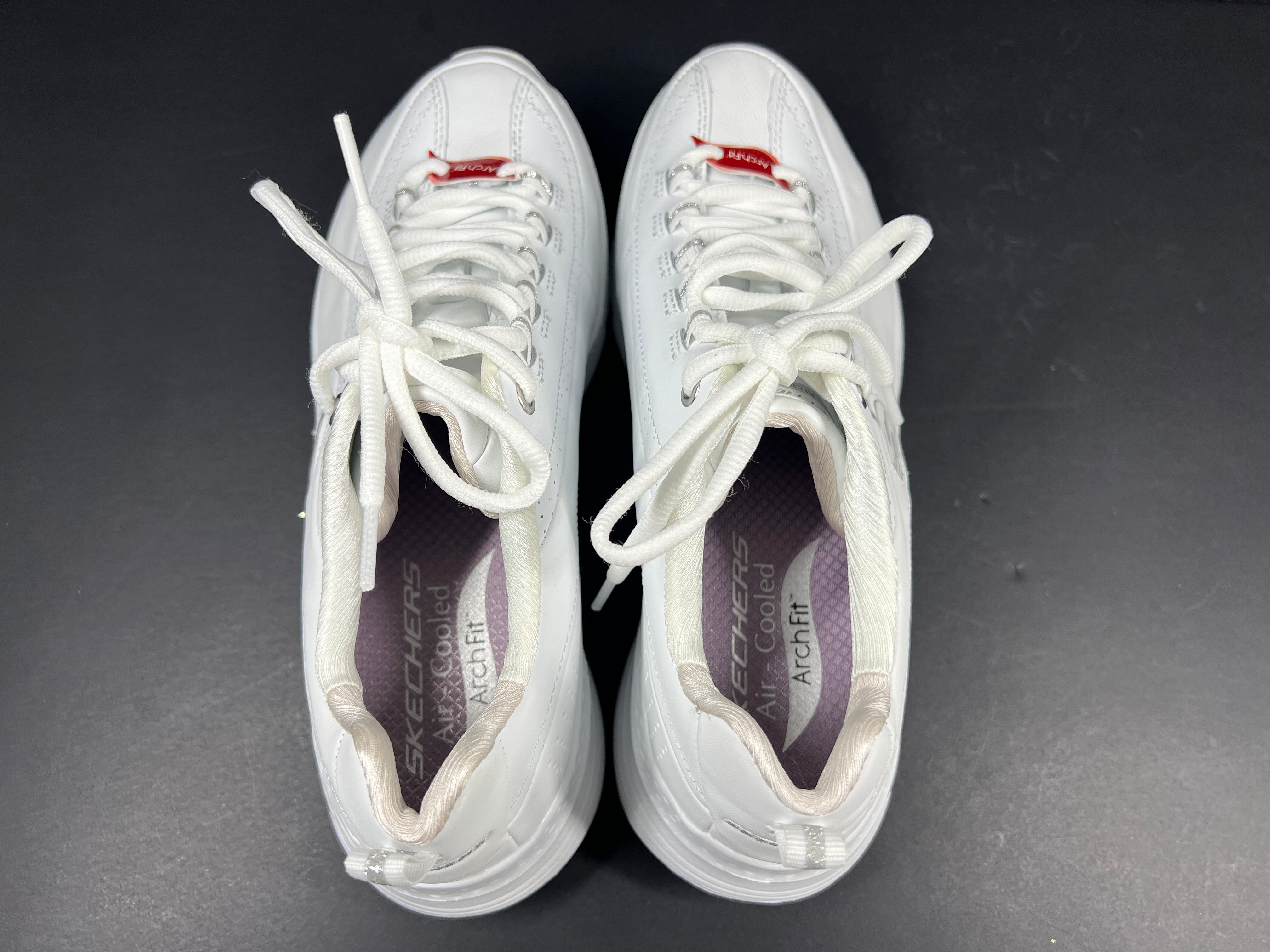 A pair of white Skechers Arch Fit women's sneakers