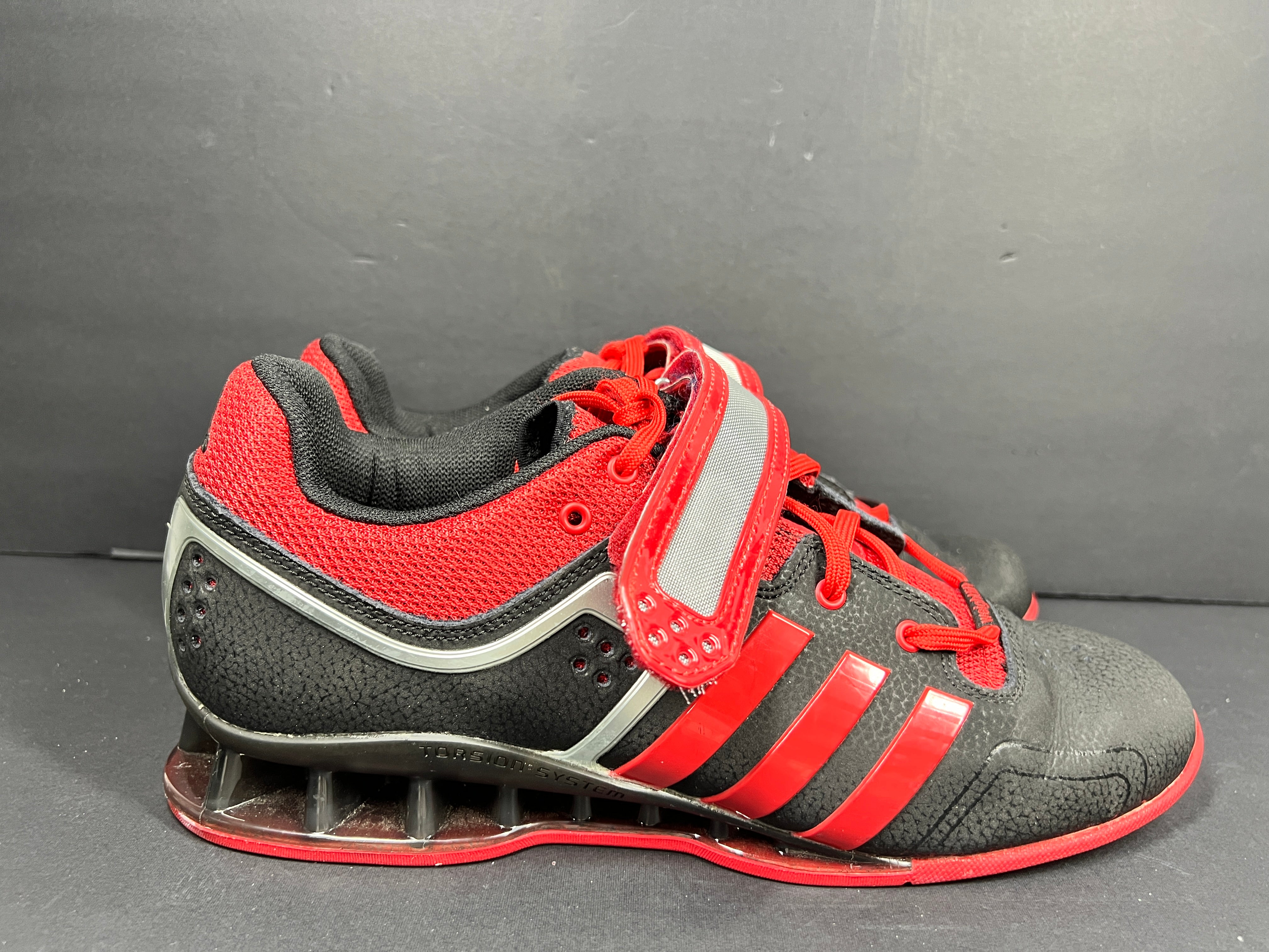 A pair of red and black Adidas Powerlift weightlifting shoes