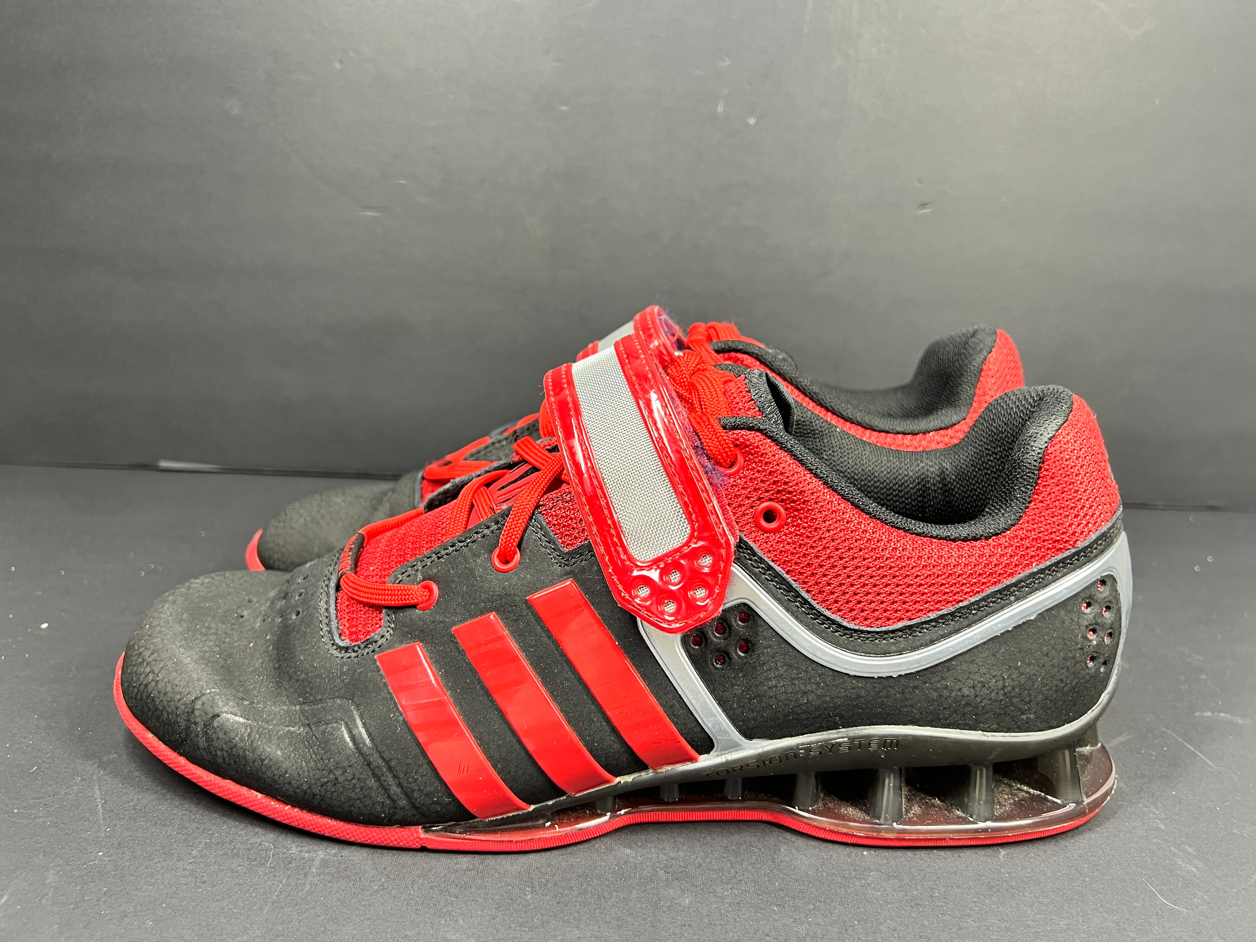 A pair of red and black Adidas Powerlift weightlifting shoes
