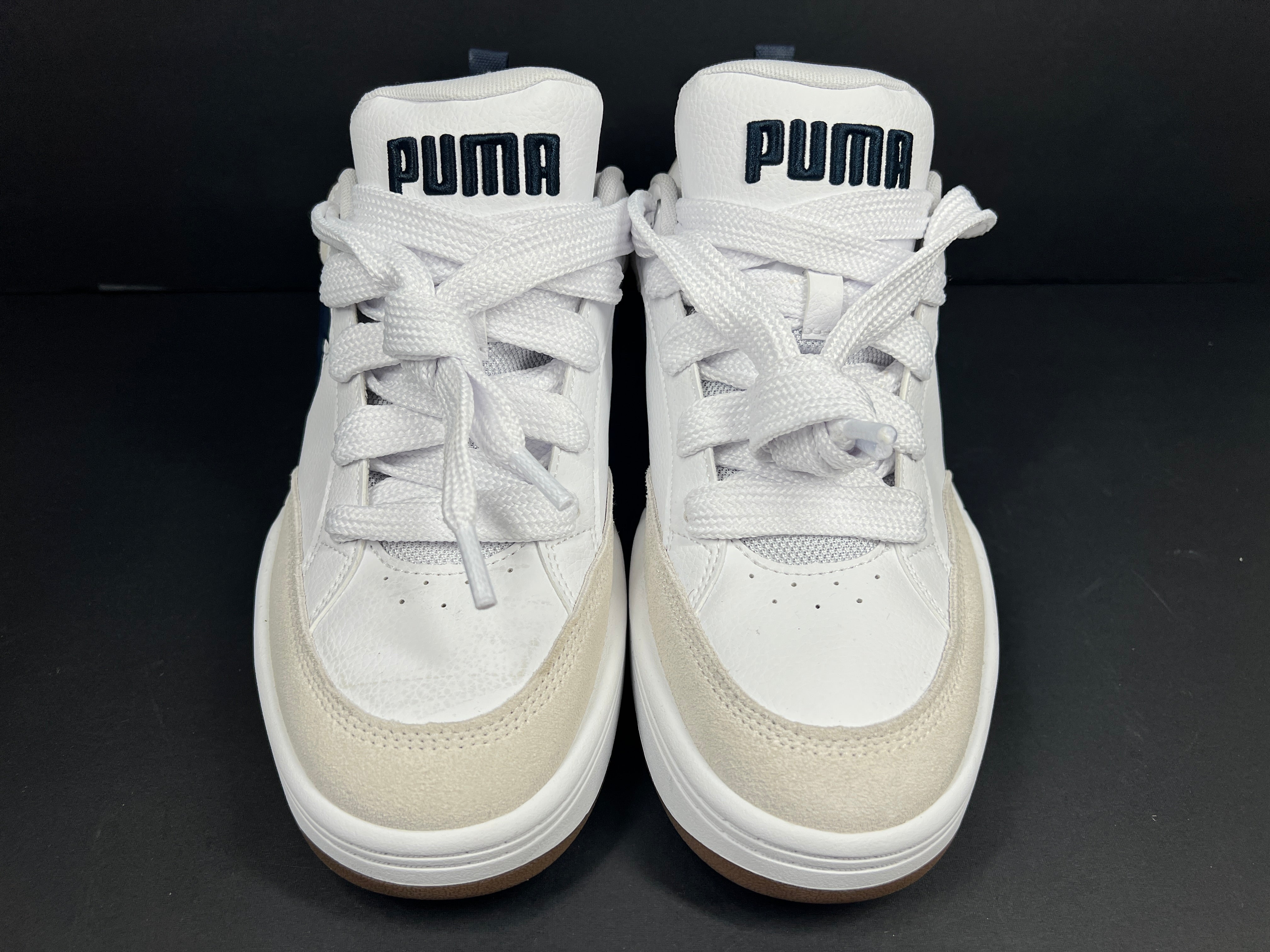 A pair of Puma sneakers in white and navy color scheme