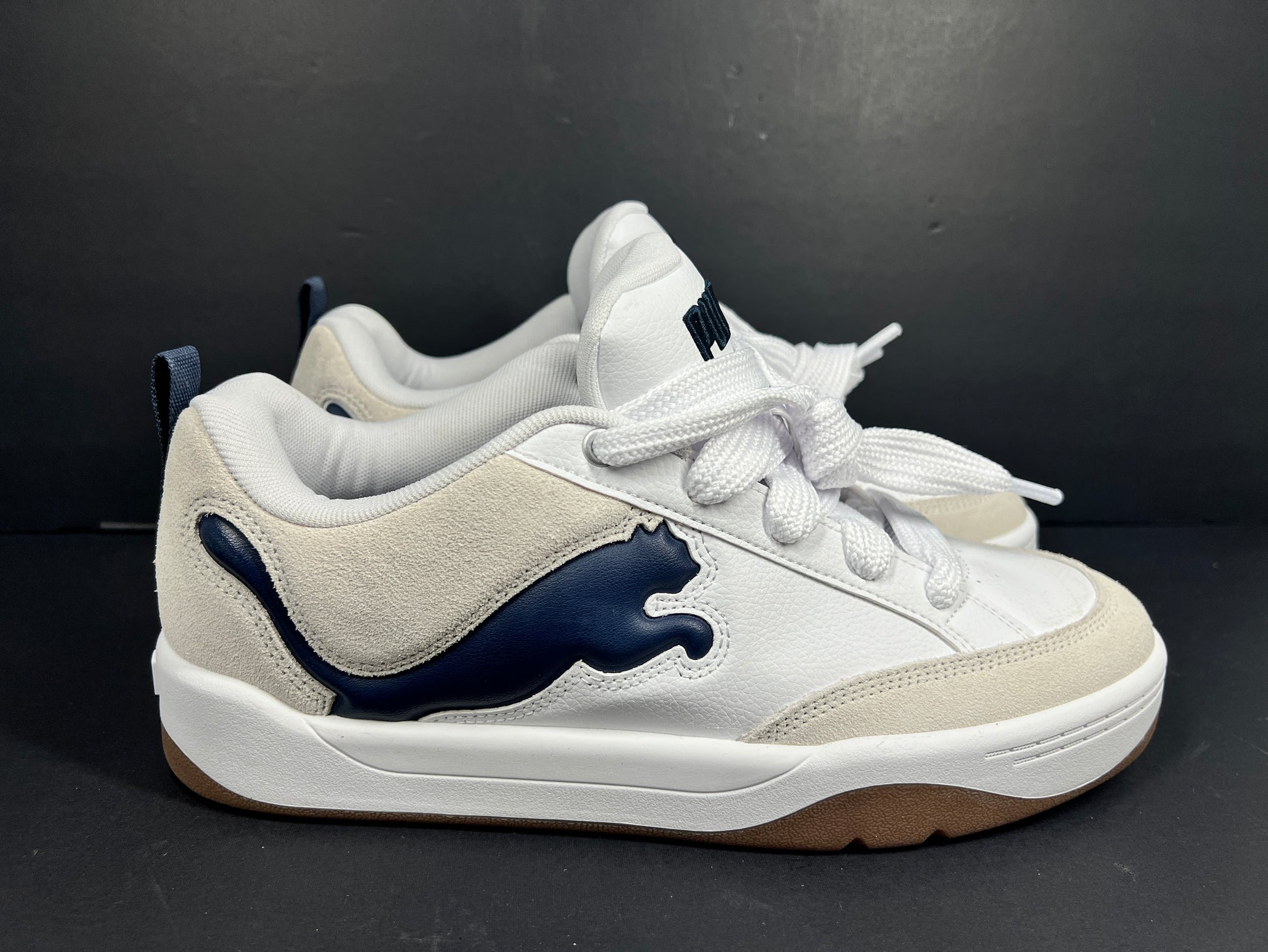 A pair of Puma sneakers in white and navy color scheme
