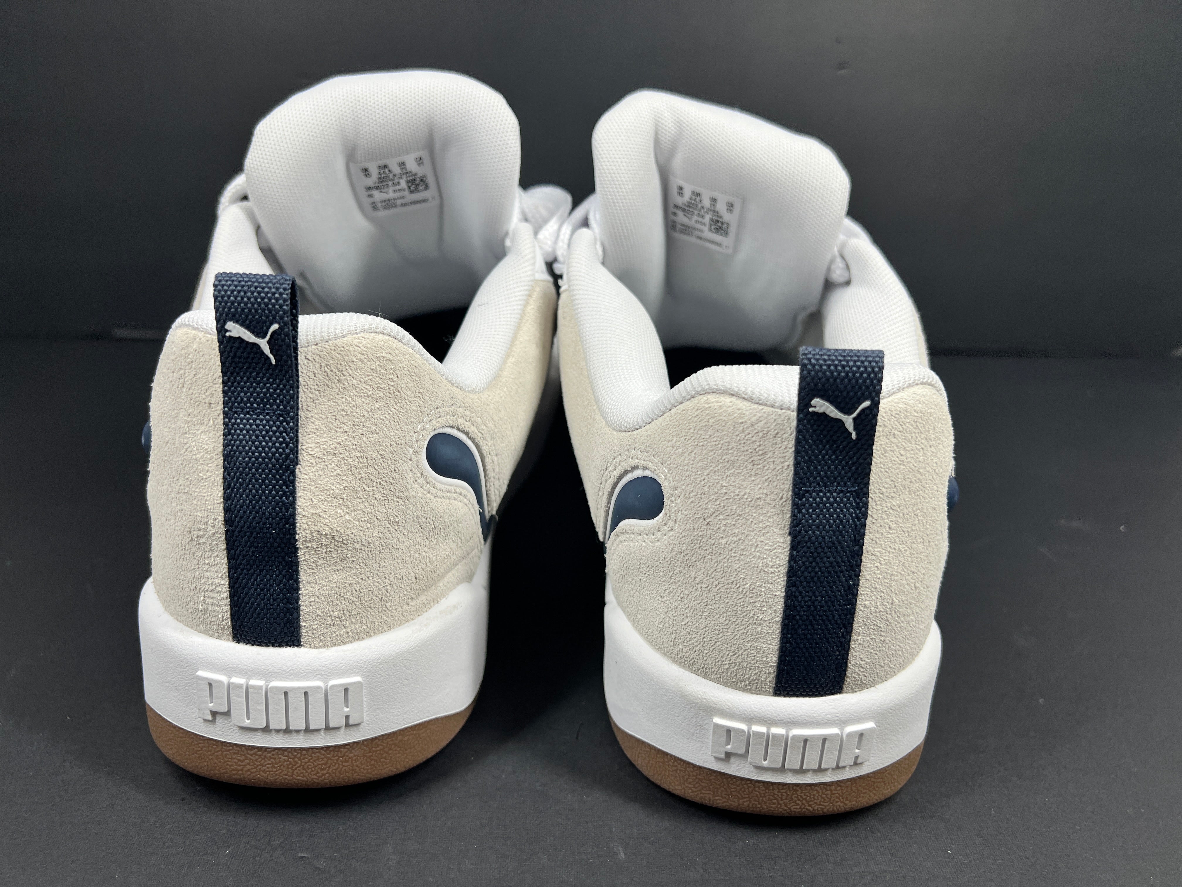 A pair of Puma sneakers in white and navy color scheme