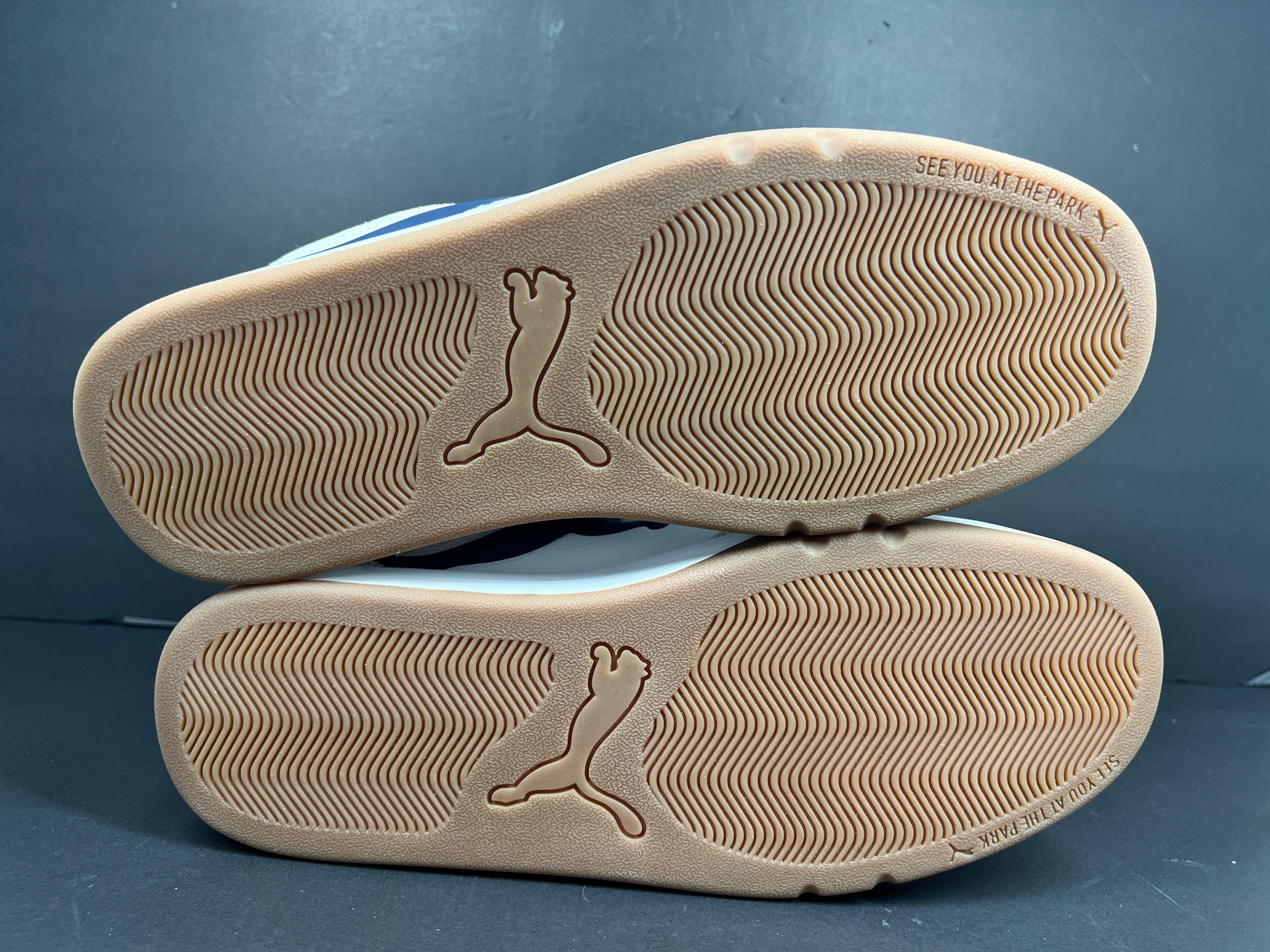 A pair of Puma sneakers in white and navy color scheme