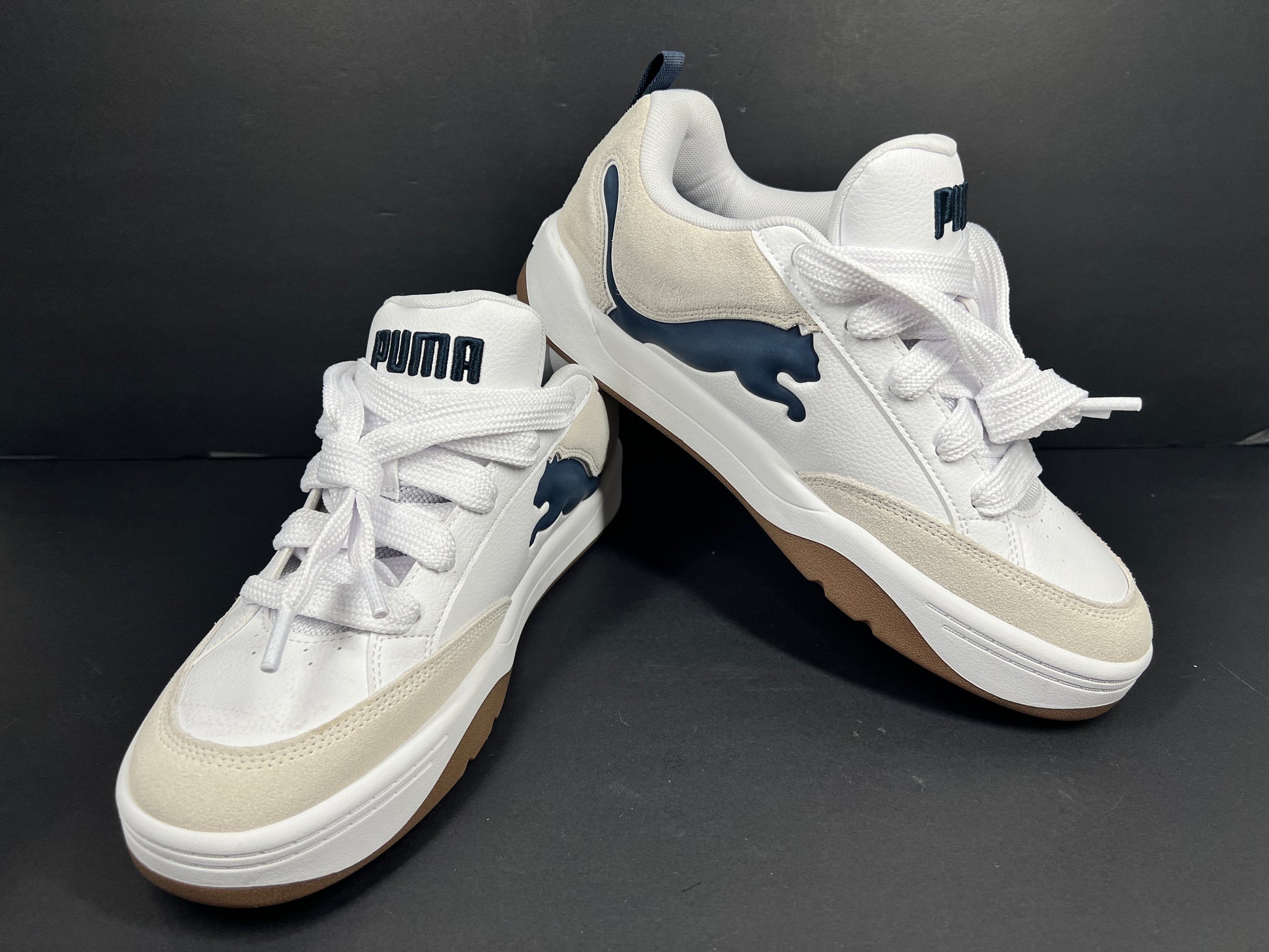 A pair of Puma sneakers in white and navy color scheme