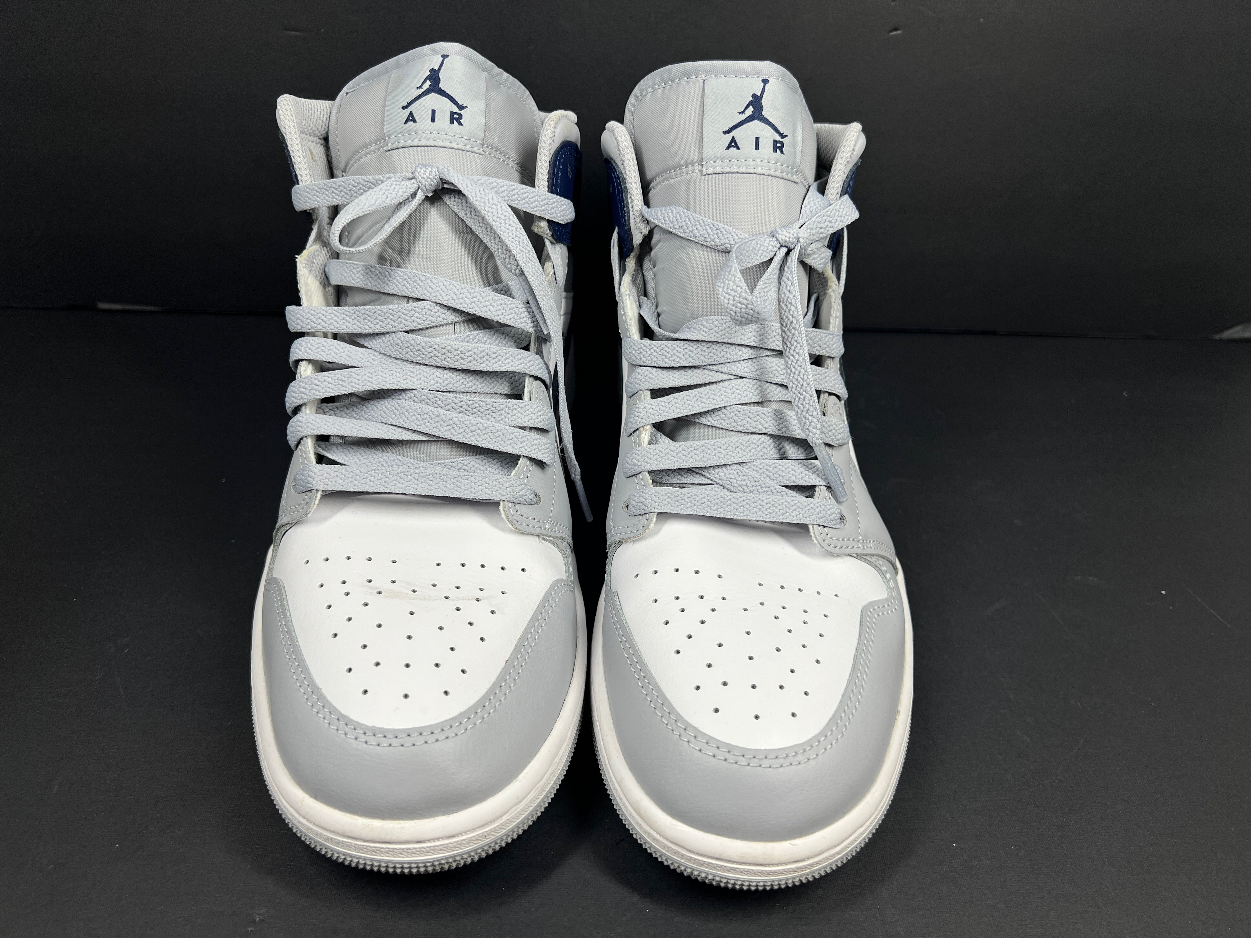 A pair of grey and white Nike Air Jordan Mid sneakers