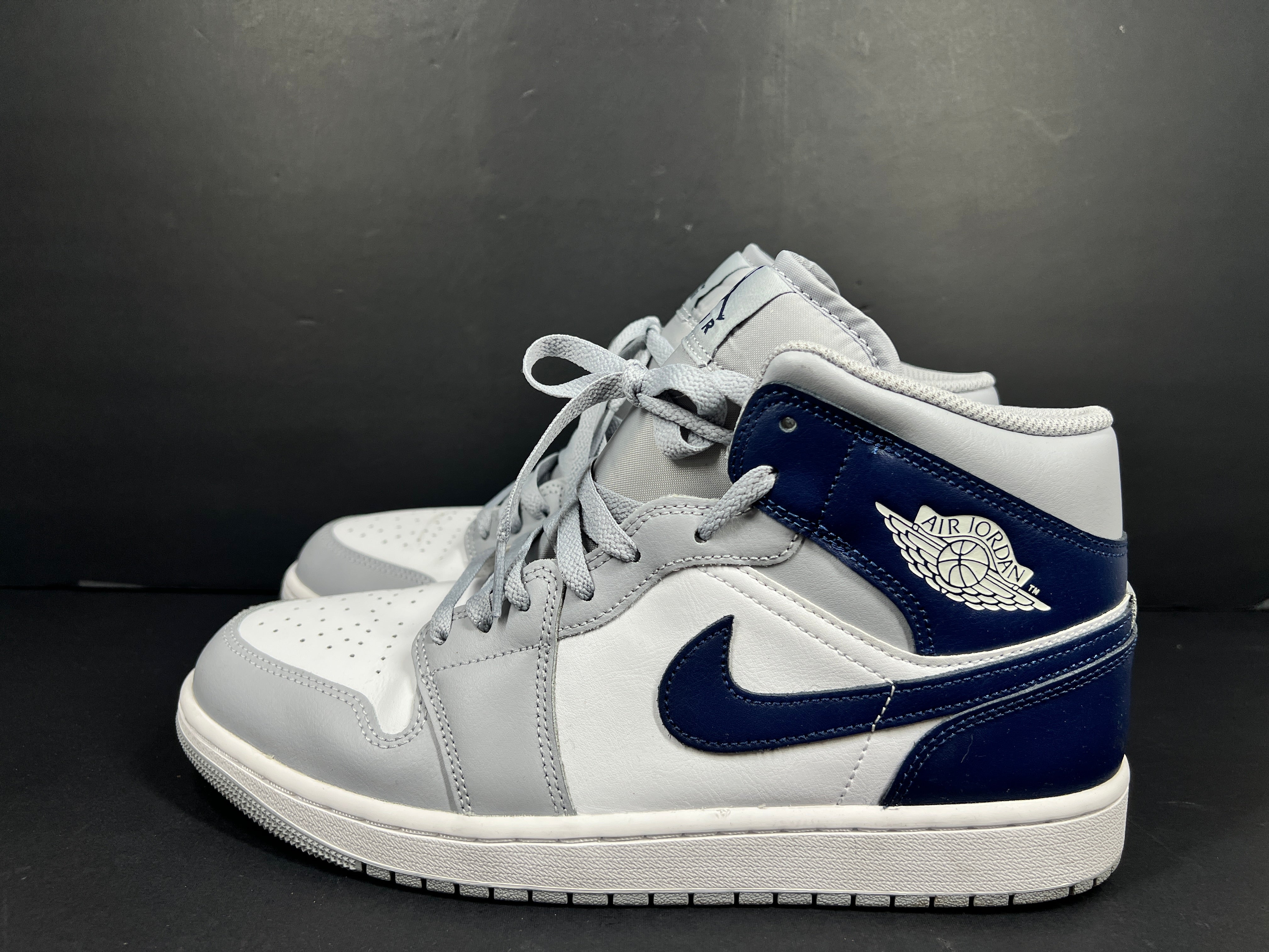 A pair of grey and white Nike Air Jordan Mid sneakers