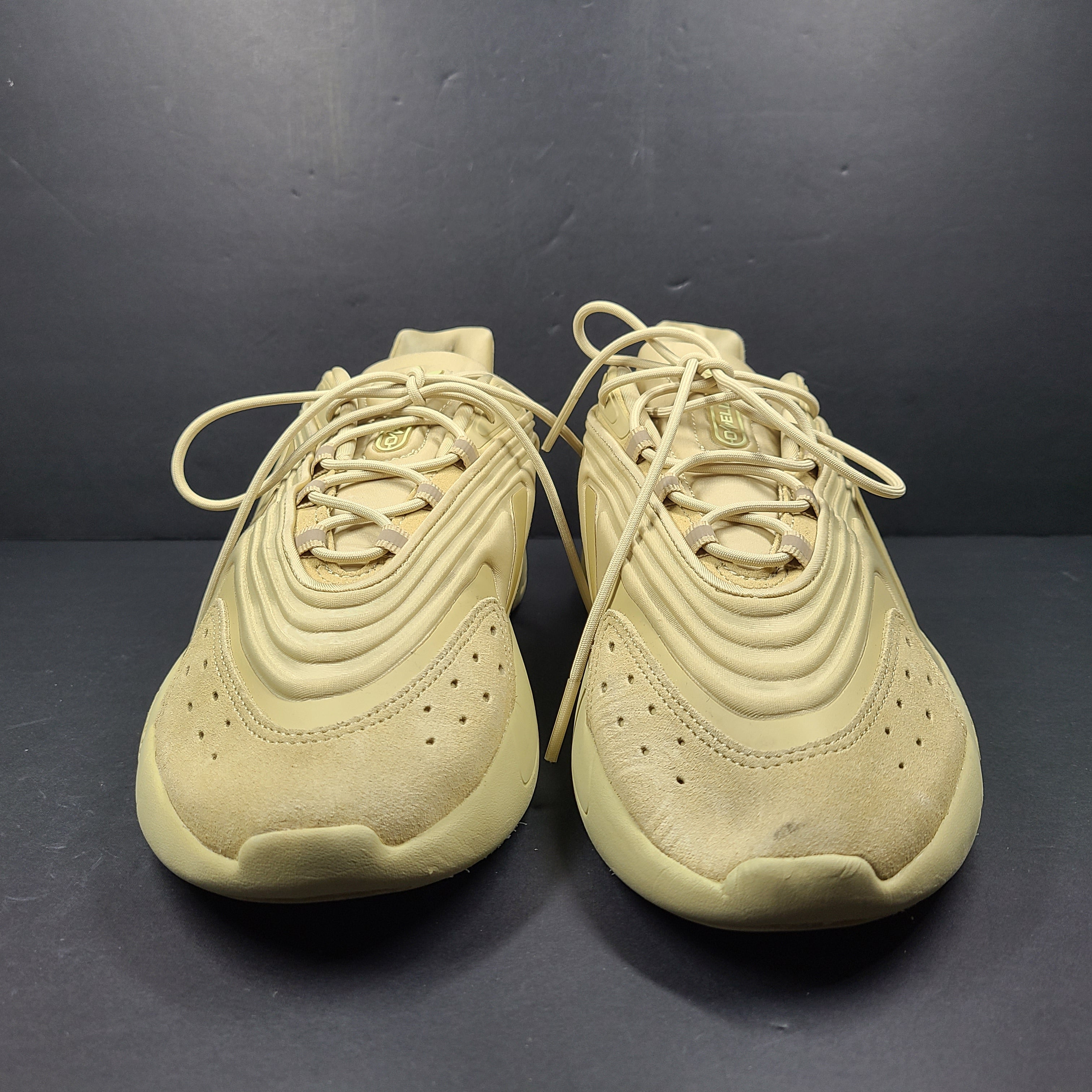 A pair of beige Adidas AdiPRENE GV7685 sneakers in size 10.