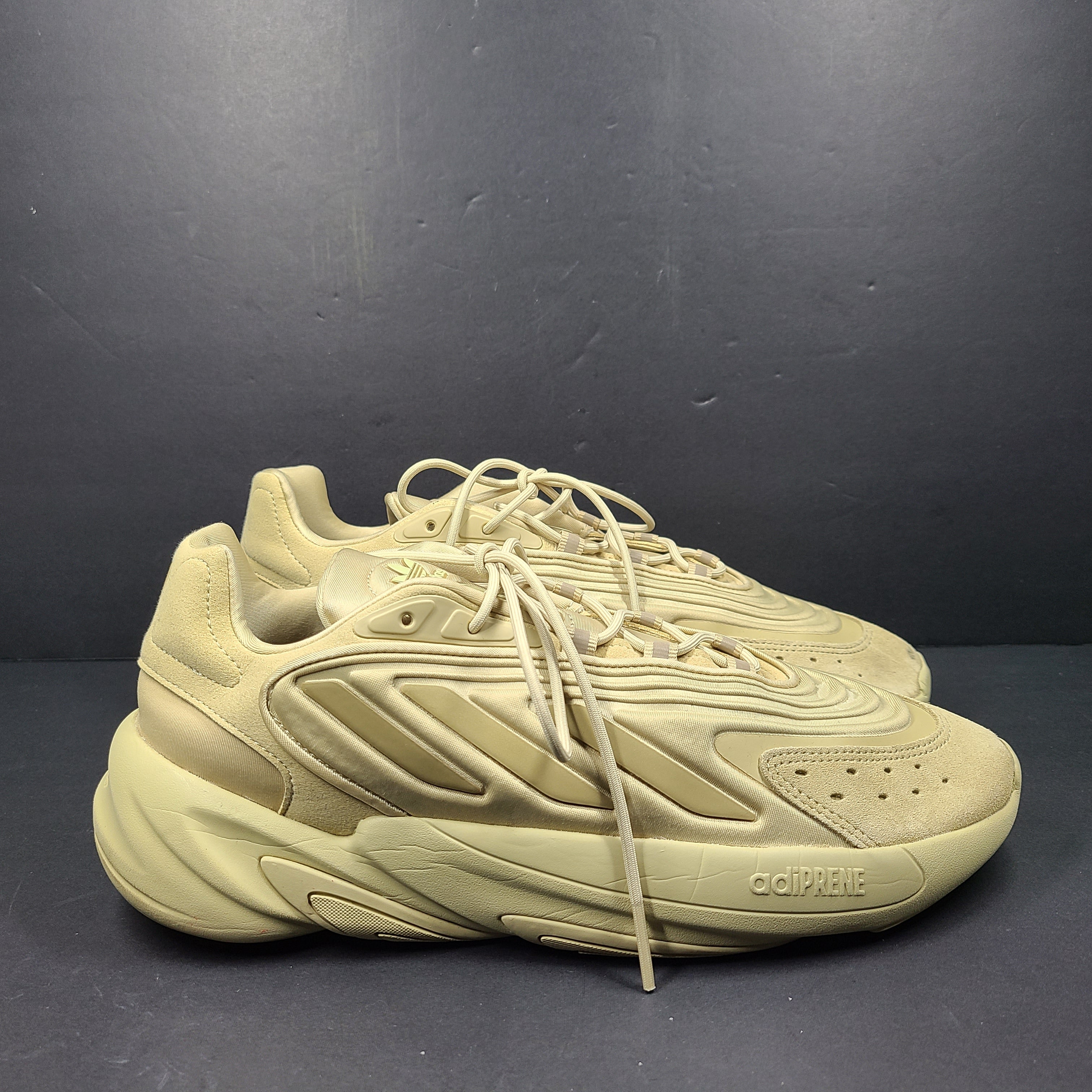 A pair of beige Adidas AdiPRENE GV7685 sneakers in size 10.