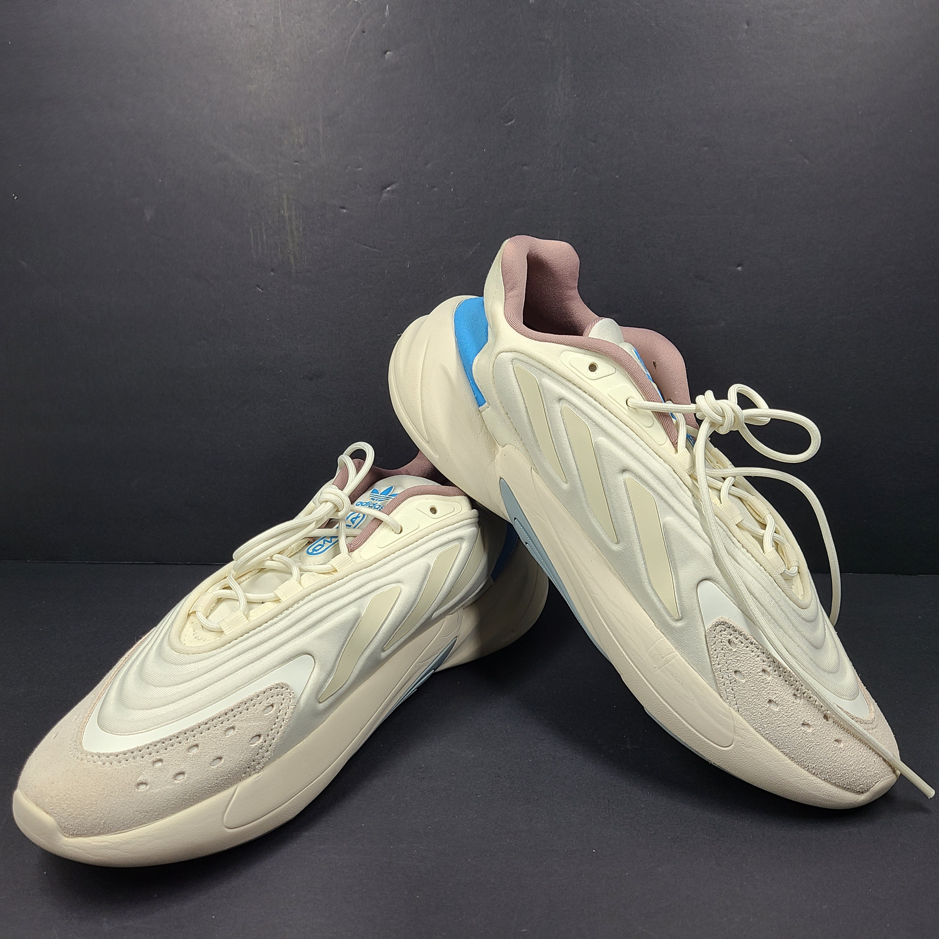 A pair of cream and blue Adidas adiPRENE sneakers in size 9.5 for men.